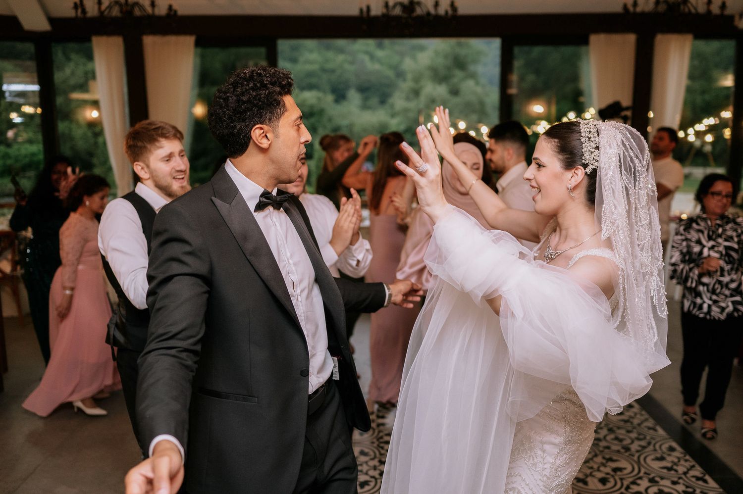Guests enjoying dance celebrations at an elegant indoor wedding reception.