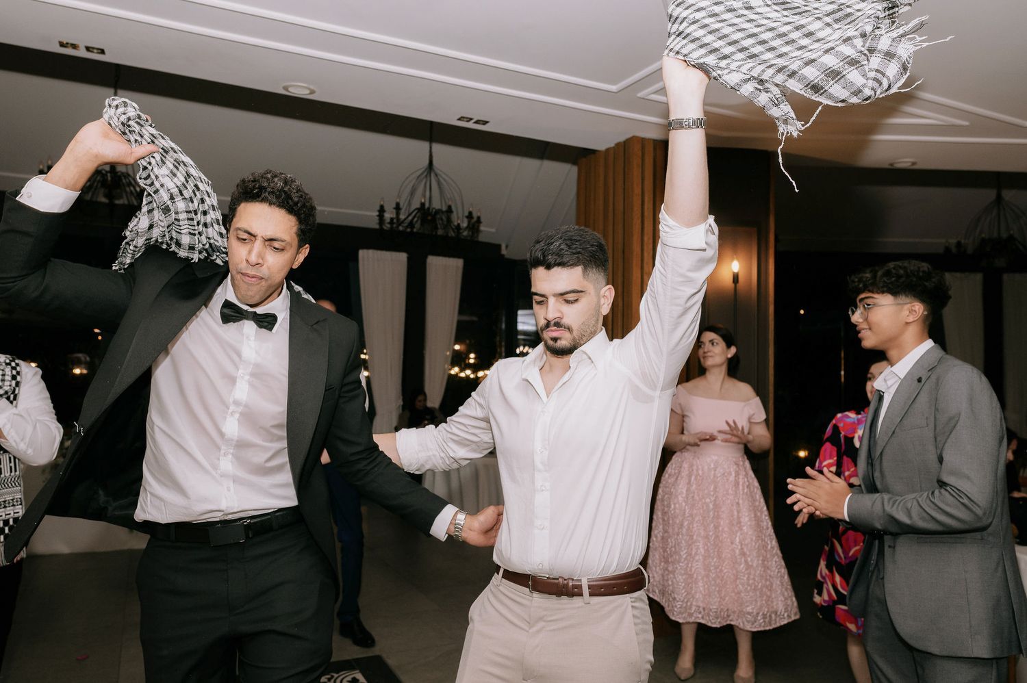 Motion-filled celebration scene with guests dancing under indoor lighting.