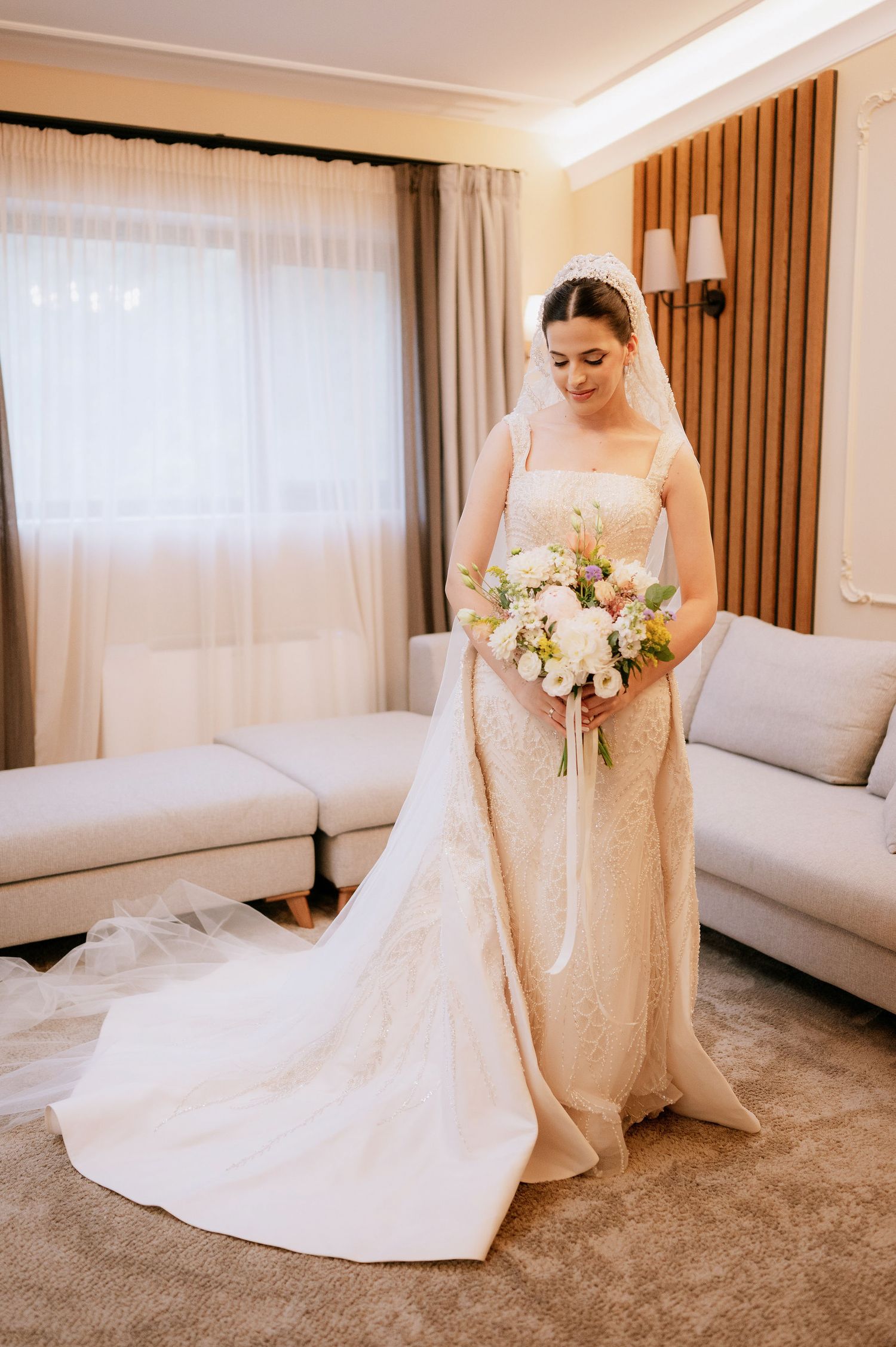 Elegant bridal portrait showing full length view of fitted wedding gown with dramatic train.