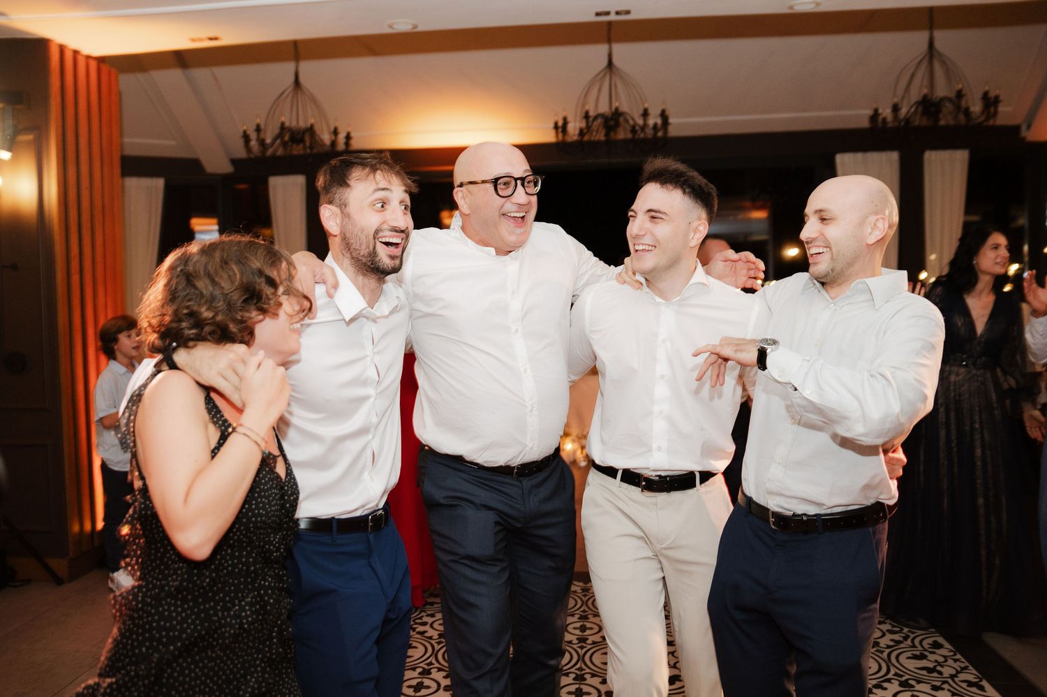 Wedding guests celebrating and dancing together during reception party.