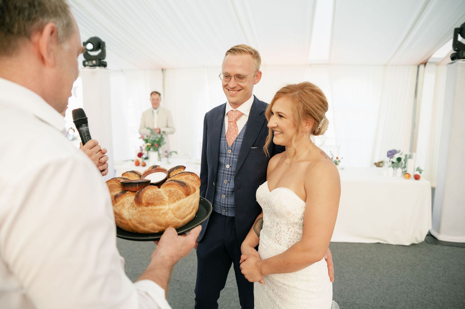 Traditional wedding bread ceremony taking place under white tent reception.
