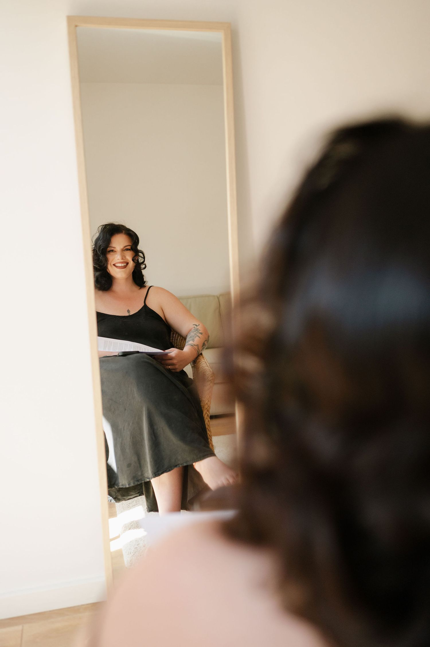 Person looking in mirror while getting ready in bright interior room.
