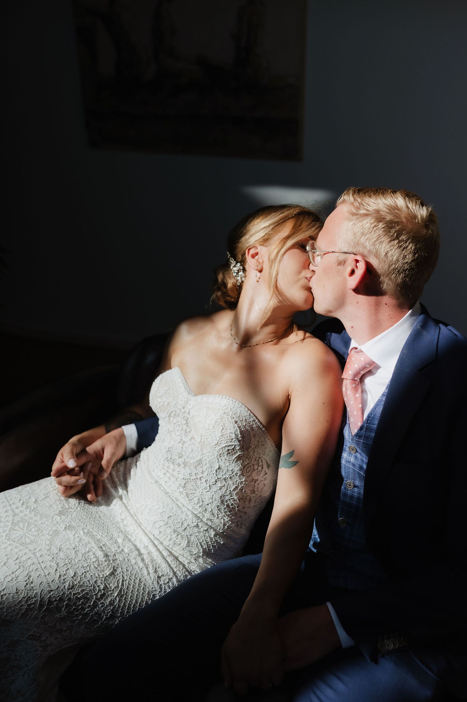 An intimate portrait of a couple embracing in contrasting light and shadow.