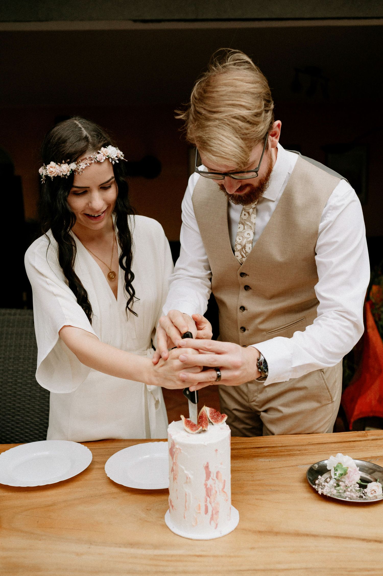 Couple shares a moment while cutting their small wedding cake together.