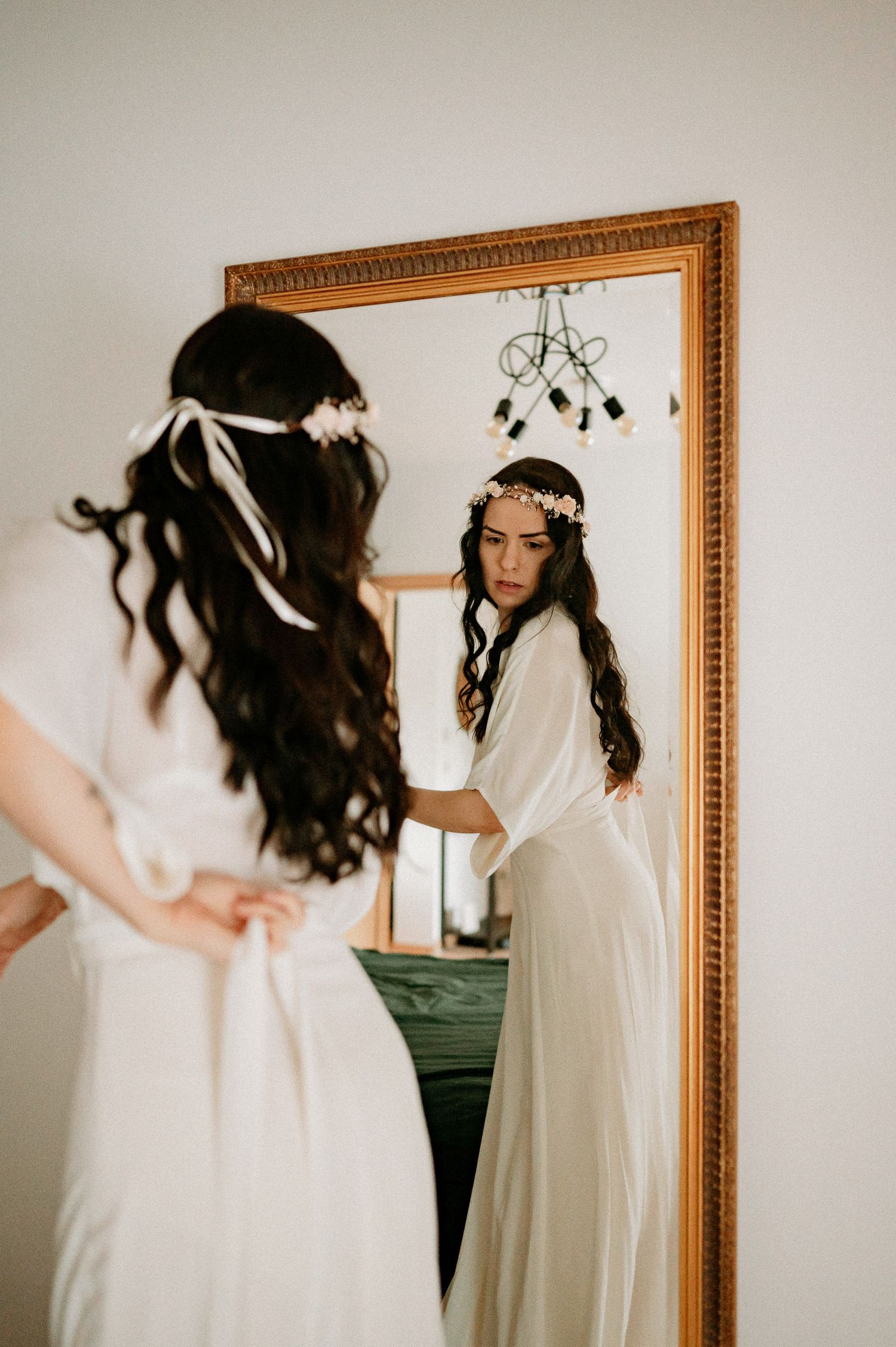 Ethereal portrait session featuring a delicate floral crown and white dress against a framed mirror.