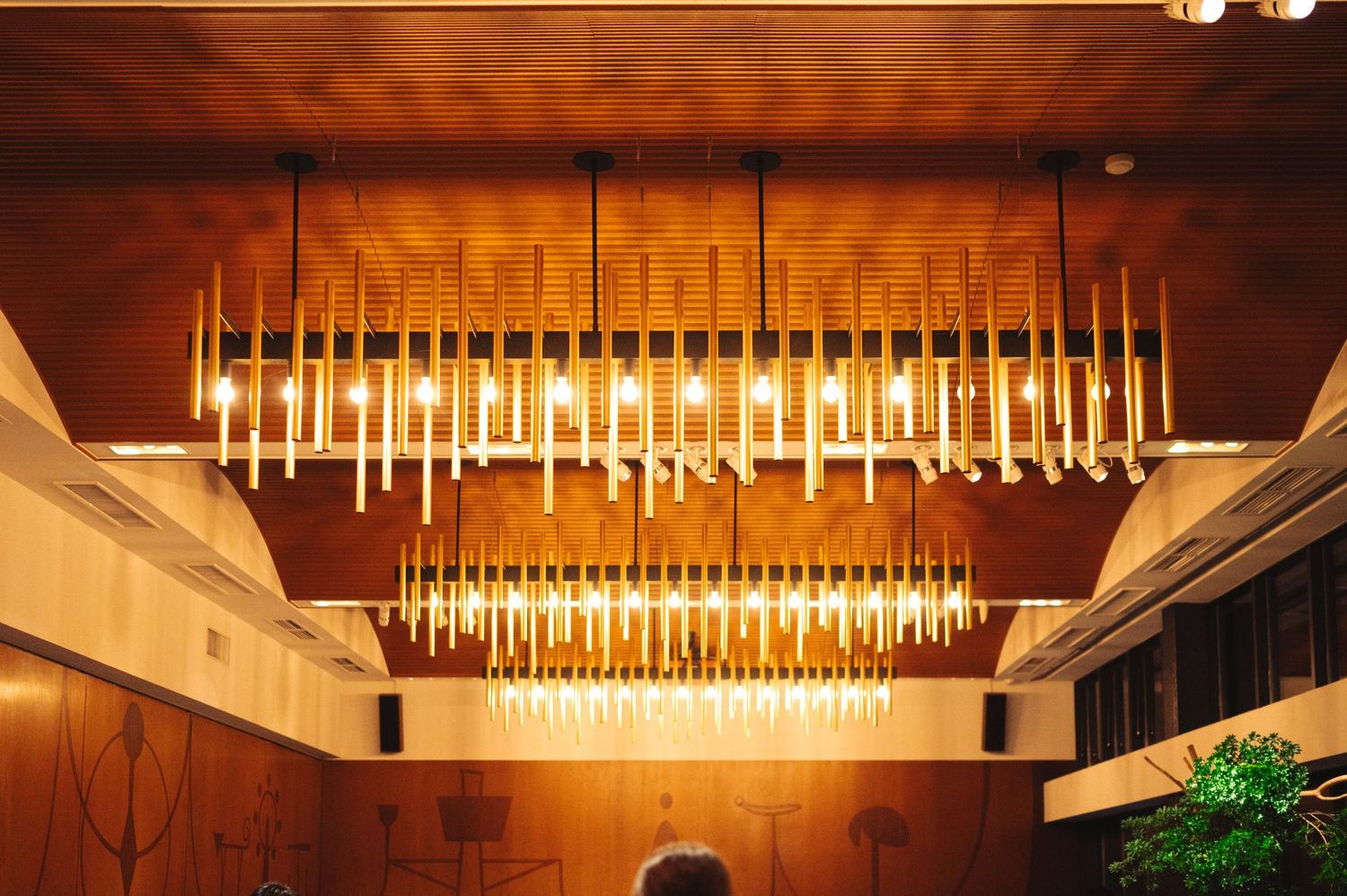 Modern rectangular chandelier illuminates an elegant dining space with warm ambient lighting.