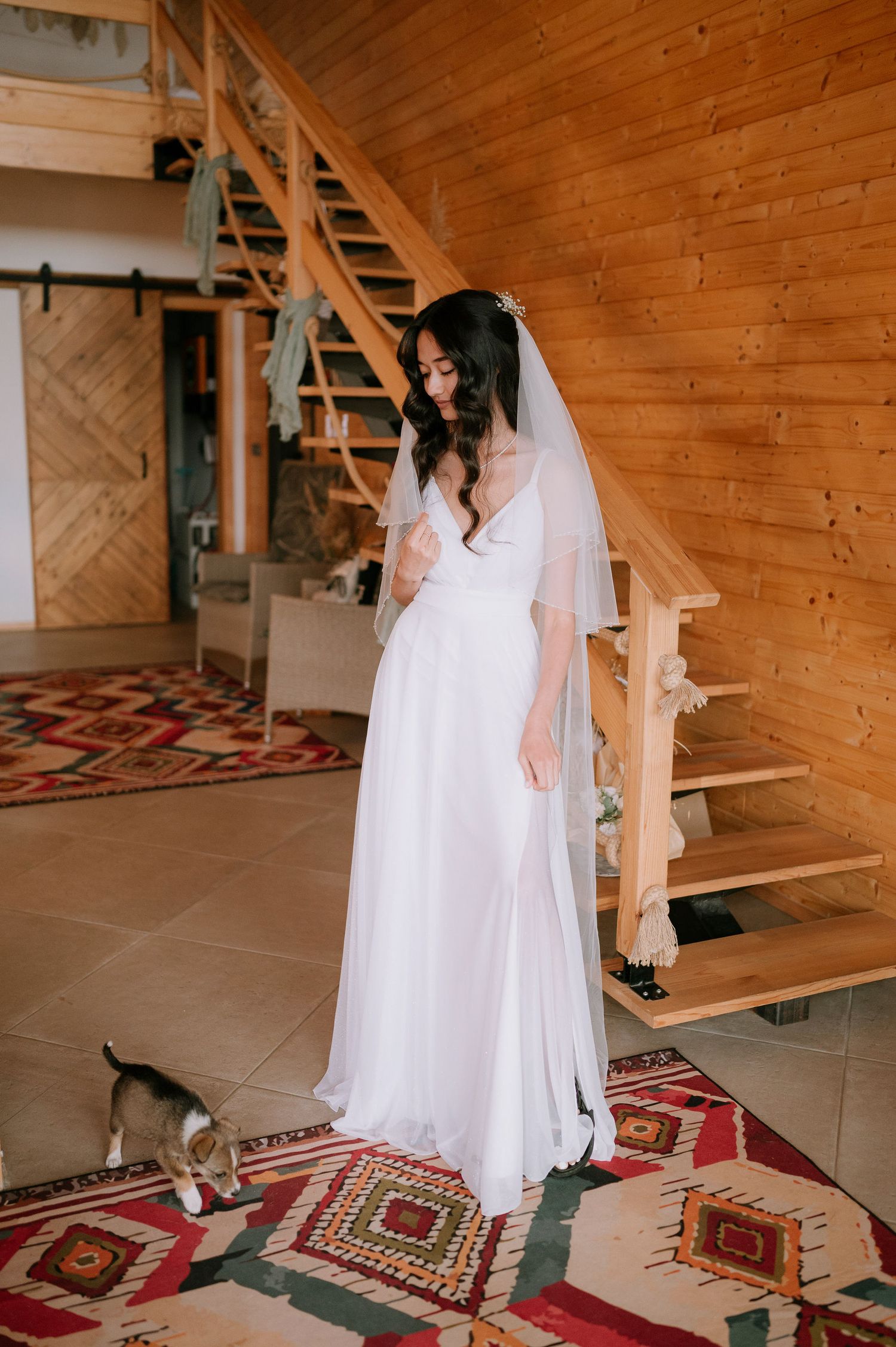 White bridal gown displayed in wooden interior with geometric patterned floor rug.