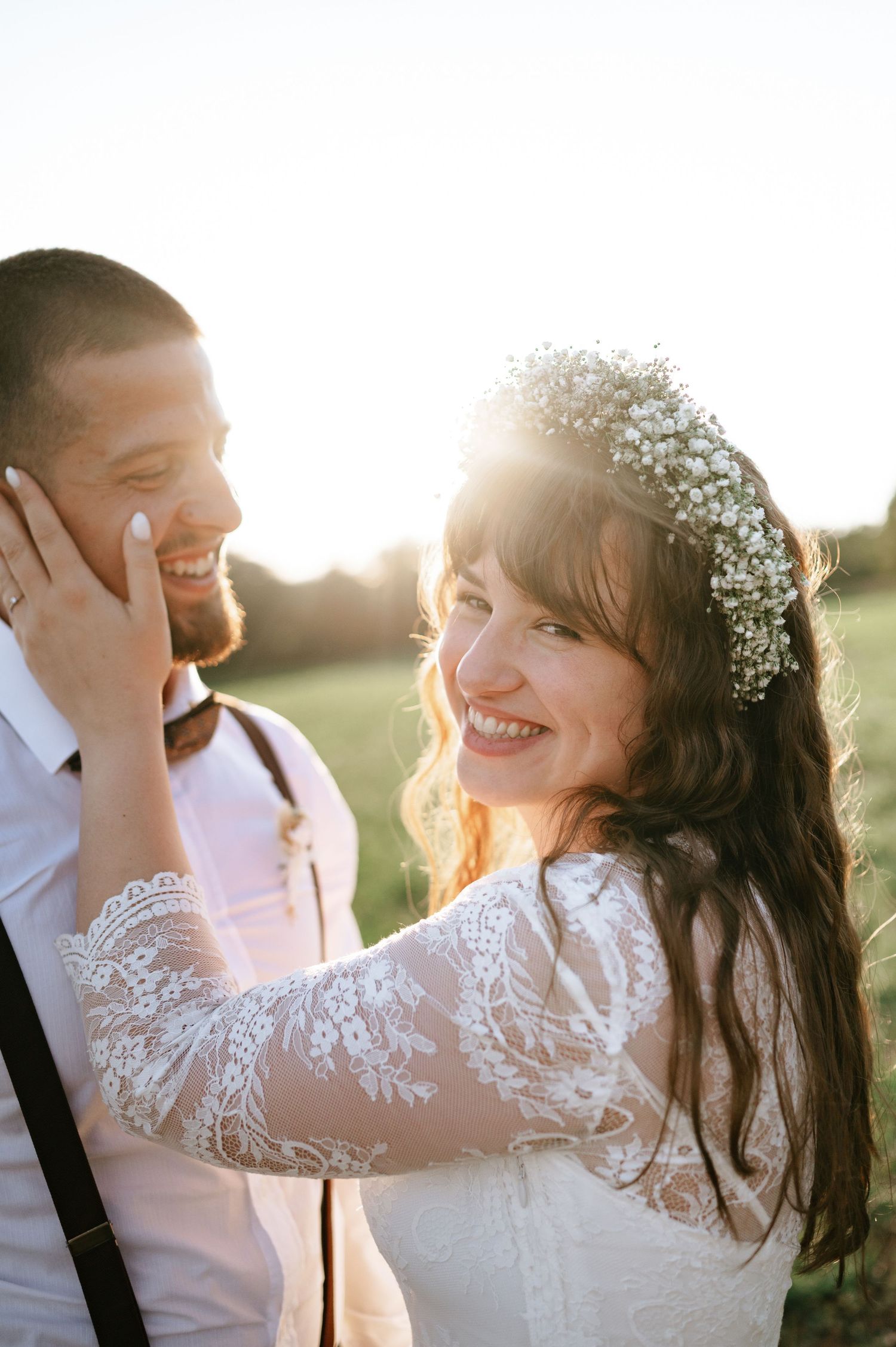 Candid moment between bride and groom sharing laughter during golden hour photography session.