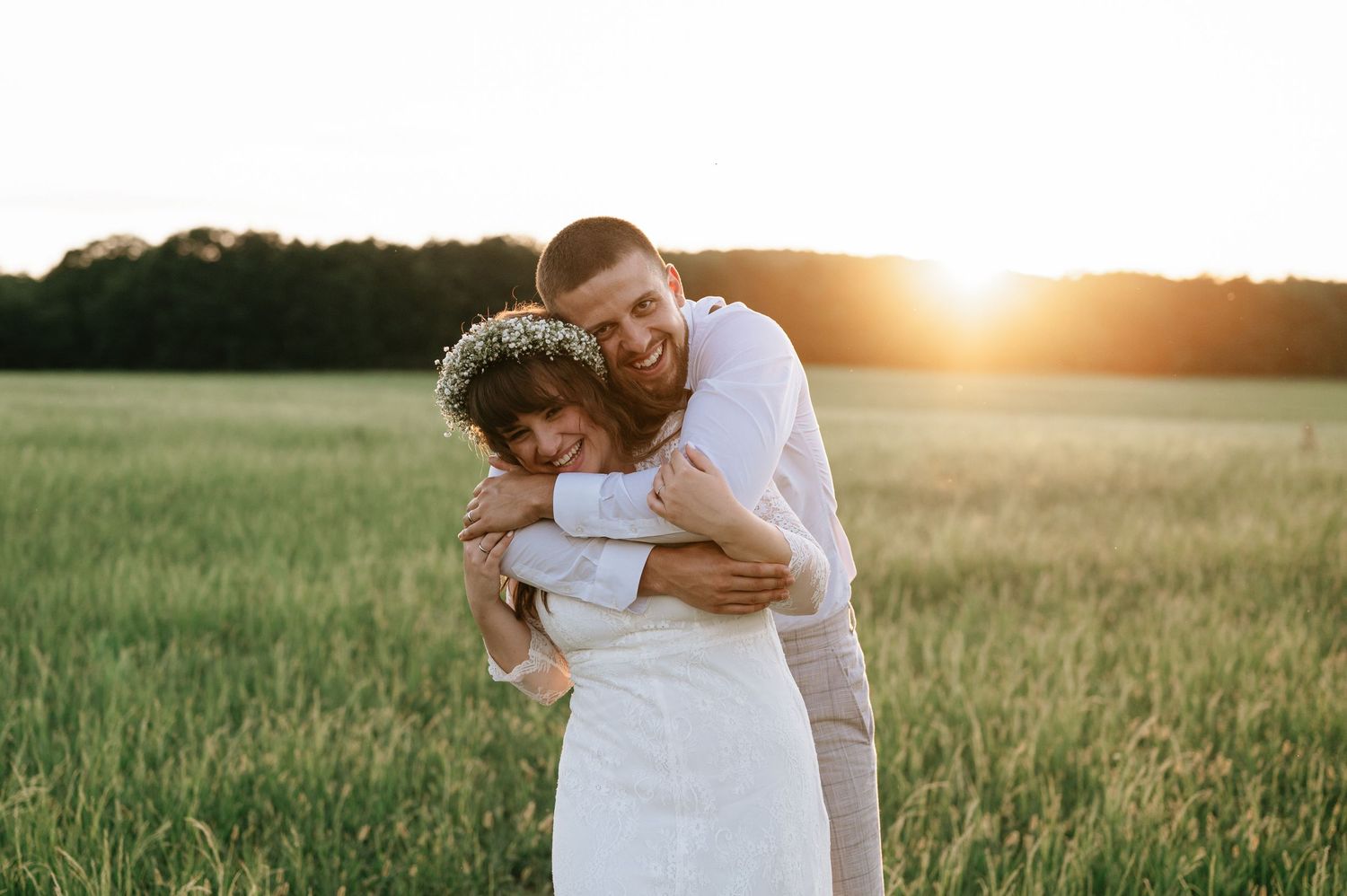 A tender sunset moment captured between newlyweds in a golden field.