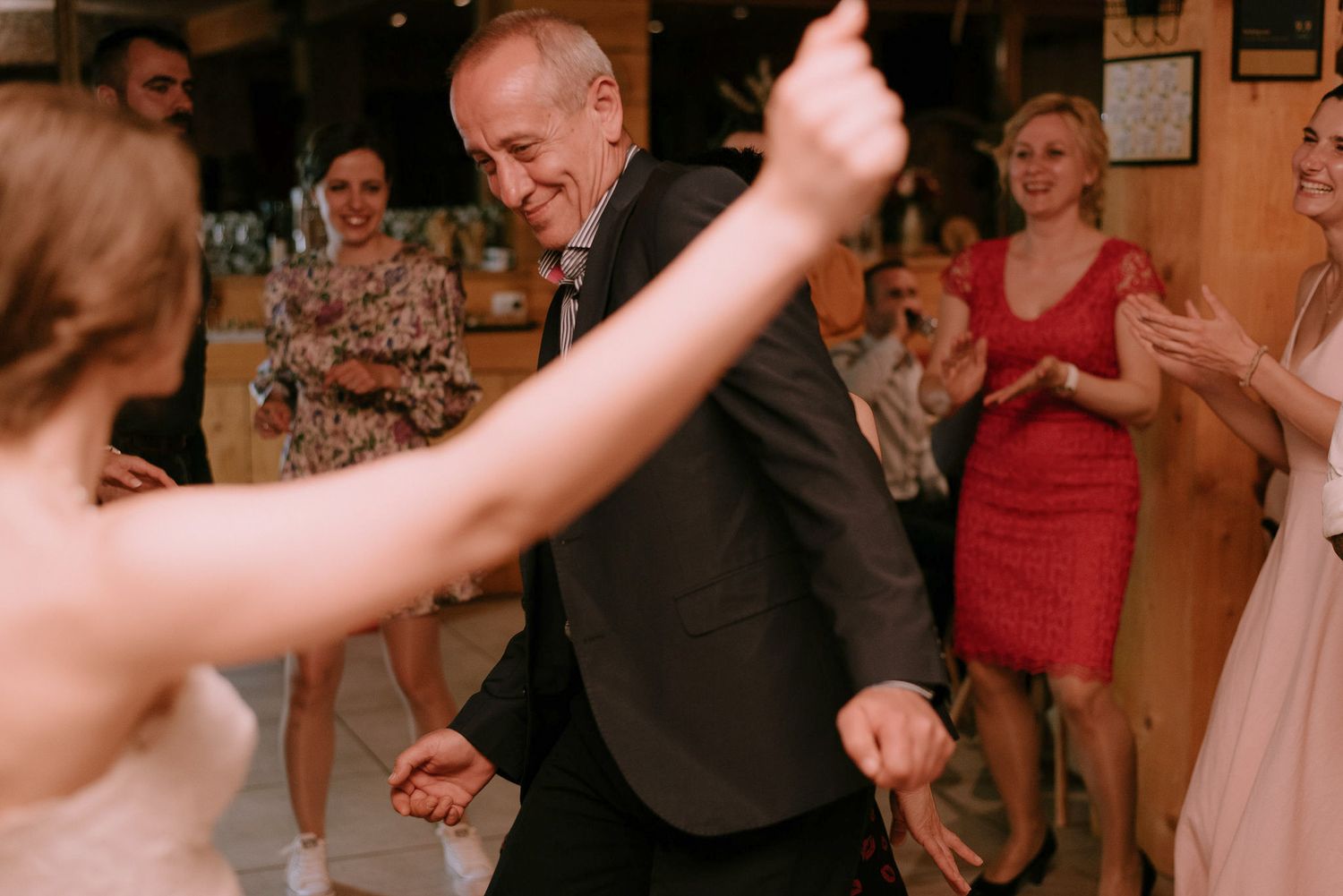 Wedding guests dancing and celebrating in a festive reception hall.