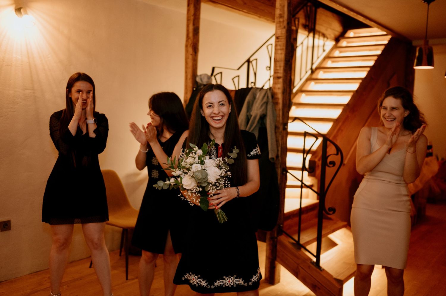 Wedding celebration with guests dancing and embracing in warm lighting.