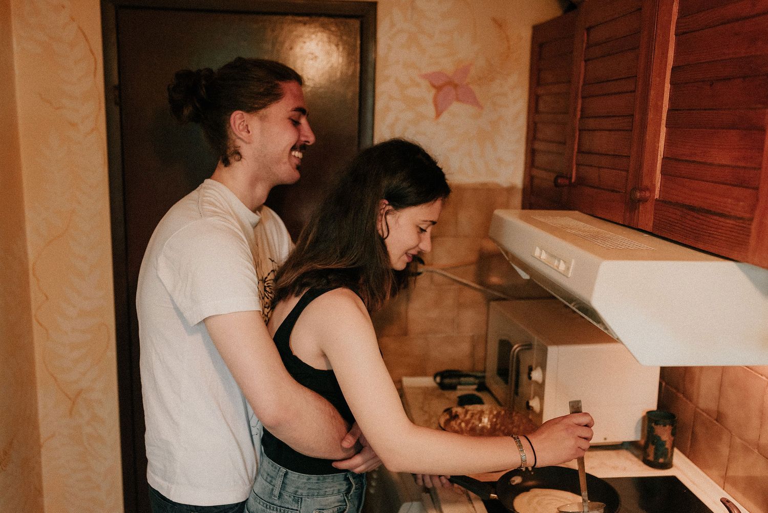 Two people cooking together in a kitchen, working side by side at the counter.