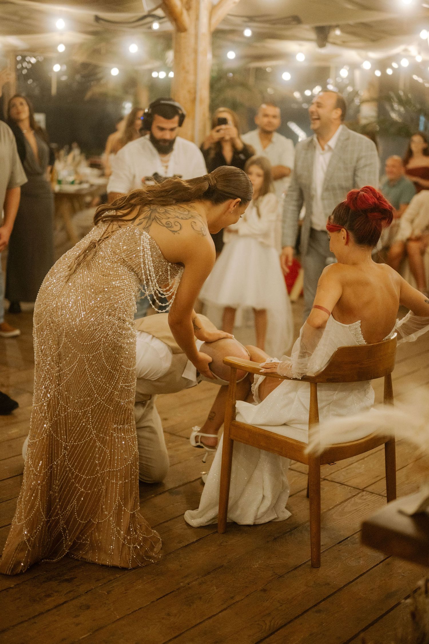A sequence of wedding reception photos showing guests participating in the limbo dance game under string lights.