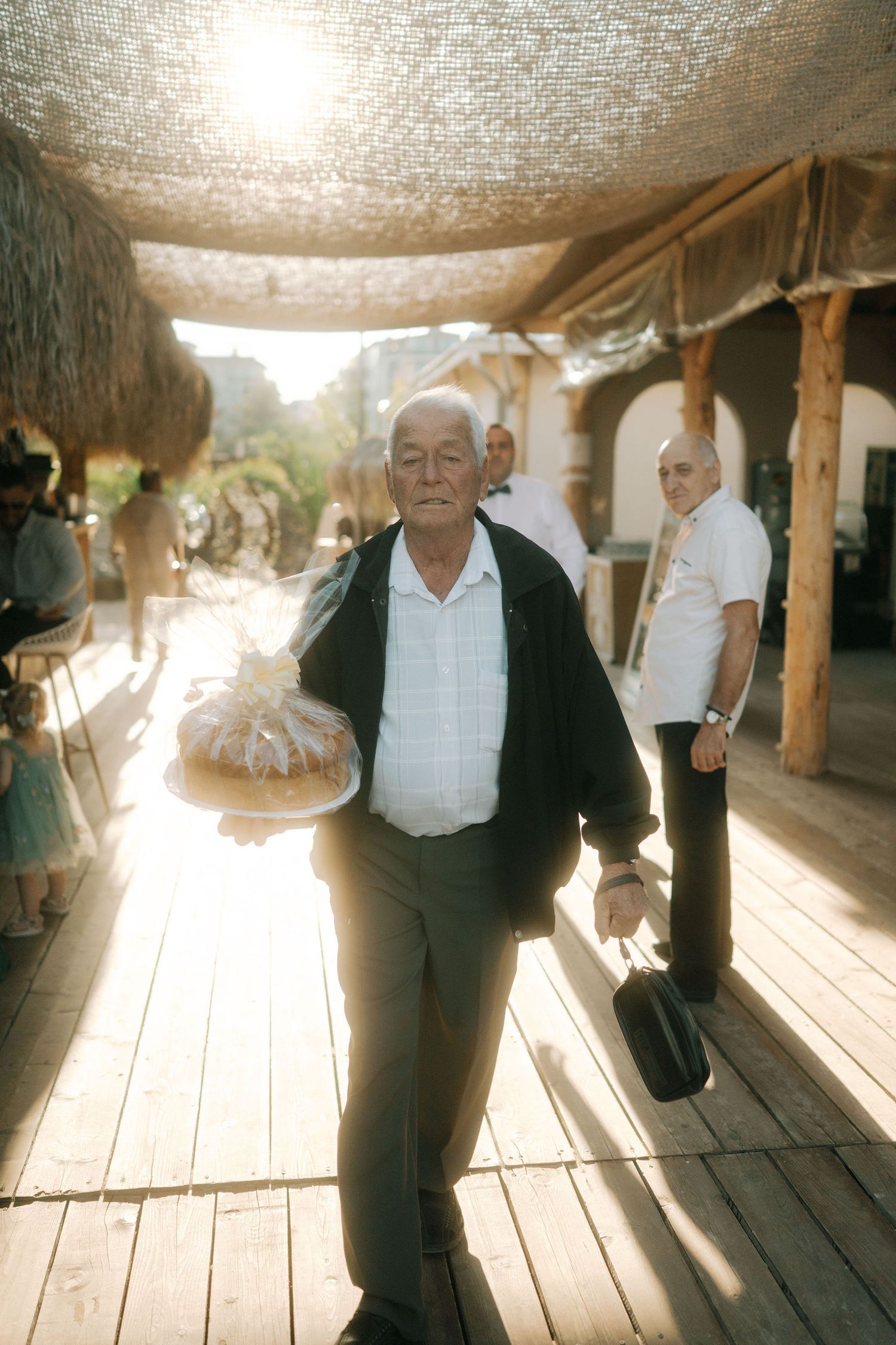 A series of motion shots showing movement and dancing in a rustic covered outdoor space with wooden flooring.