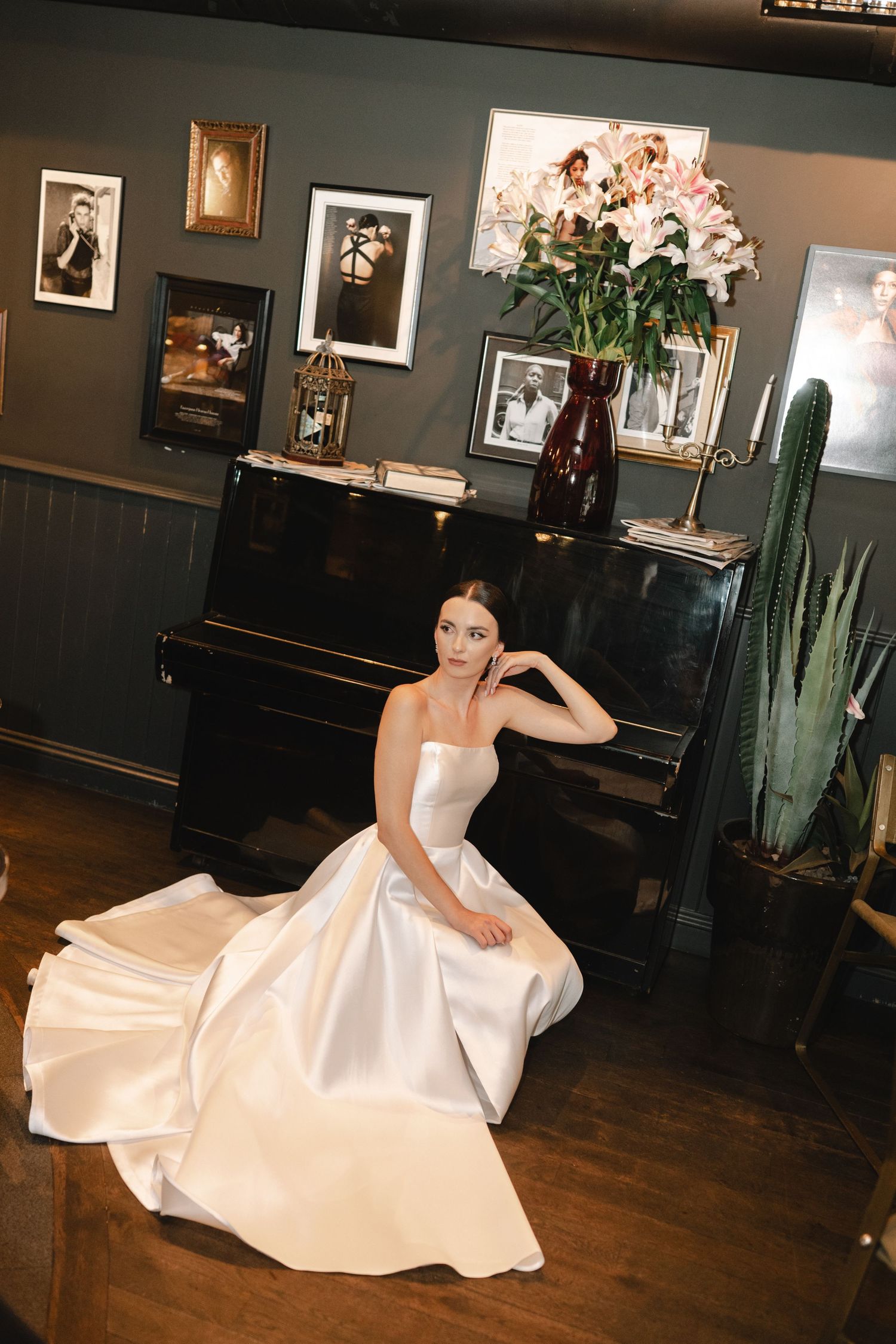 A bridal portrait series showing a flowing white wedding gown against dark walls and hardwood floors in an elegant room.