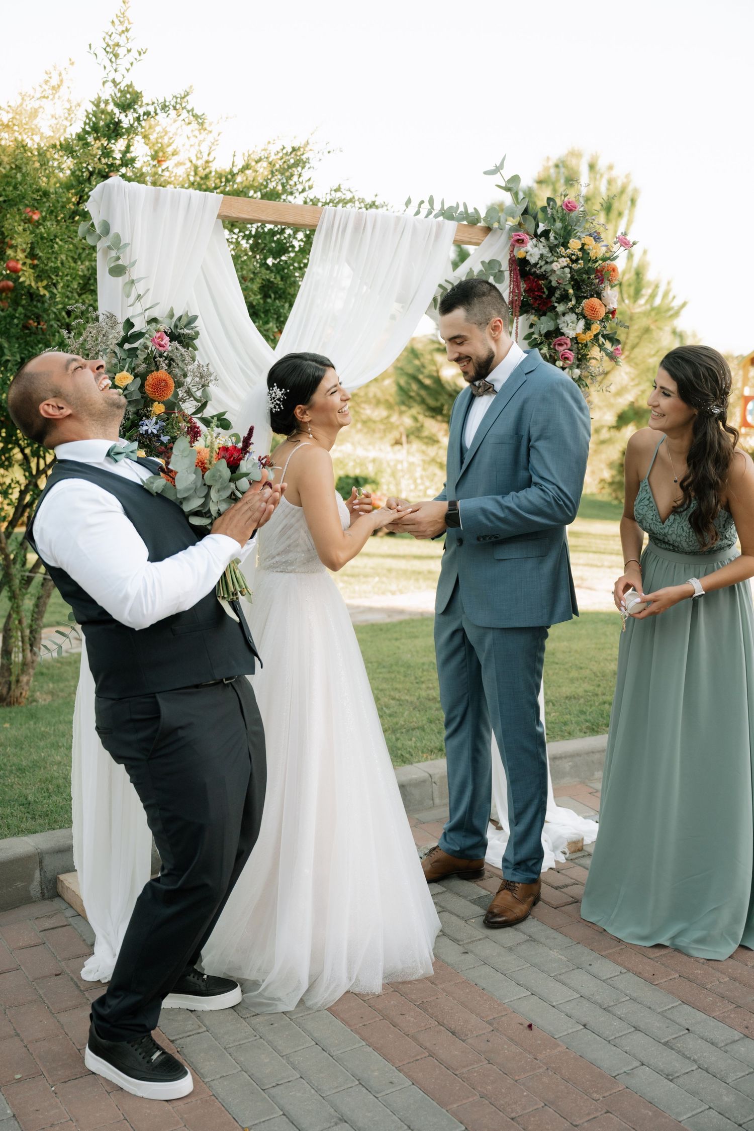 A sequence of wedding photos shows a fun moment between wedding party members posing playfully on brick pavers outdoors.