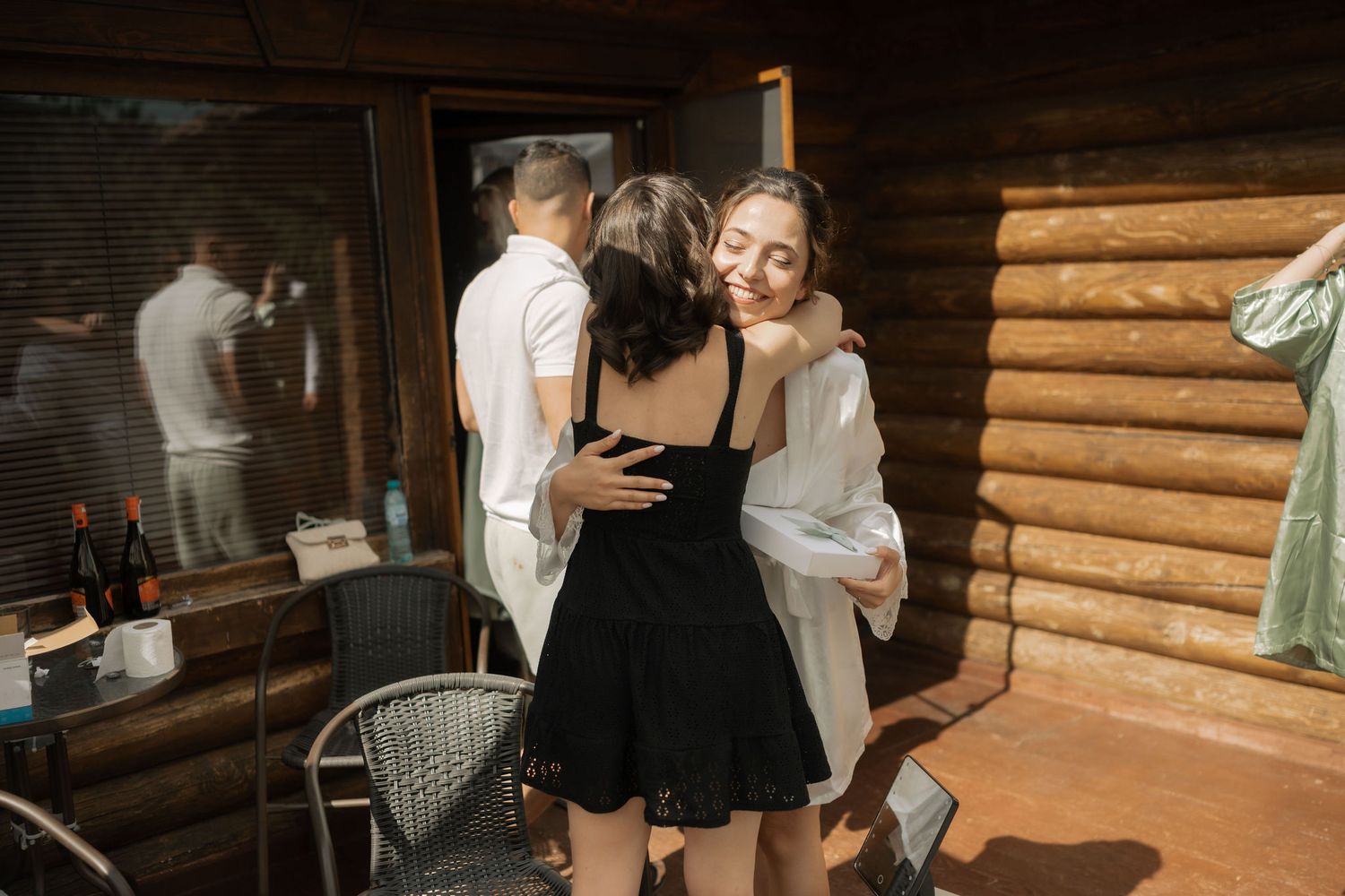 Guests gather inside a rustic log cabin venue for a social event with wooden beams and warm lighting.