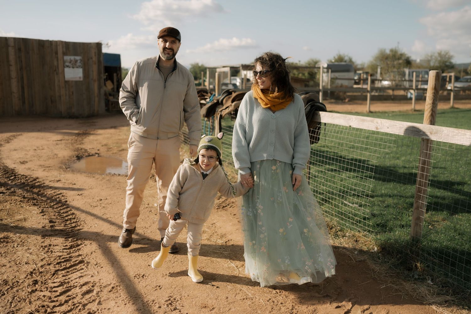 A couple walks together along a dusty path during a sunset photo session in the desert.