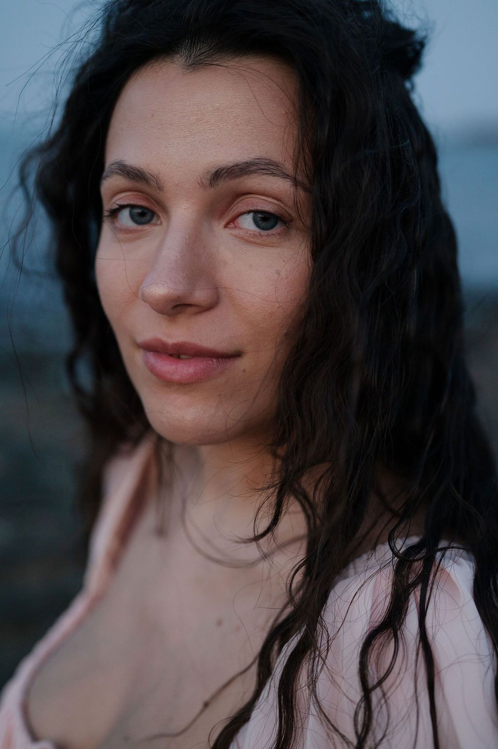 Portrait series showing close-up expressions against a dusky background in soft lighting.