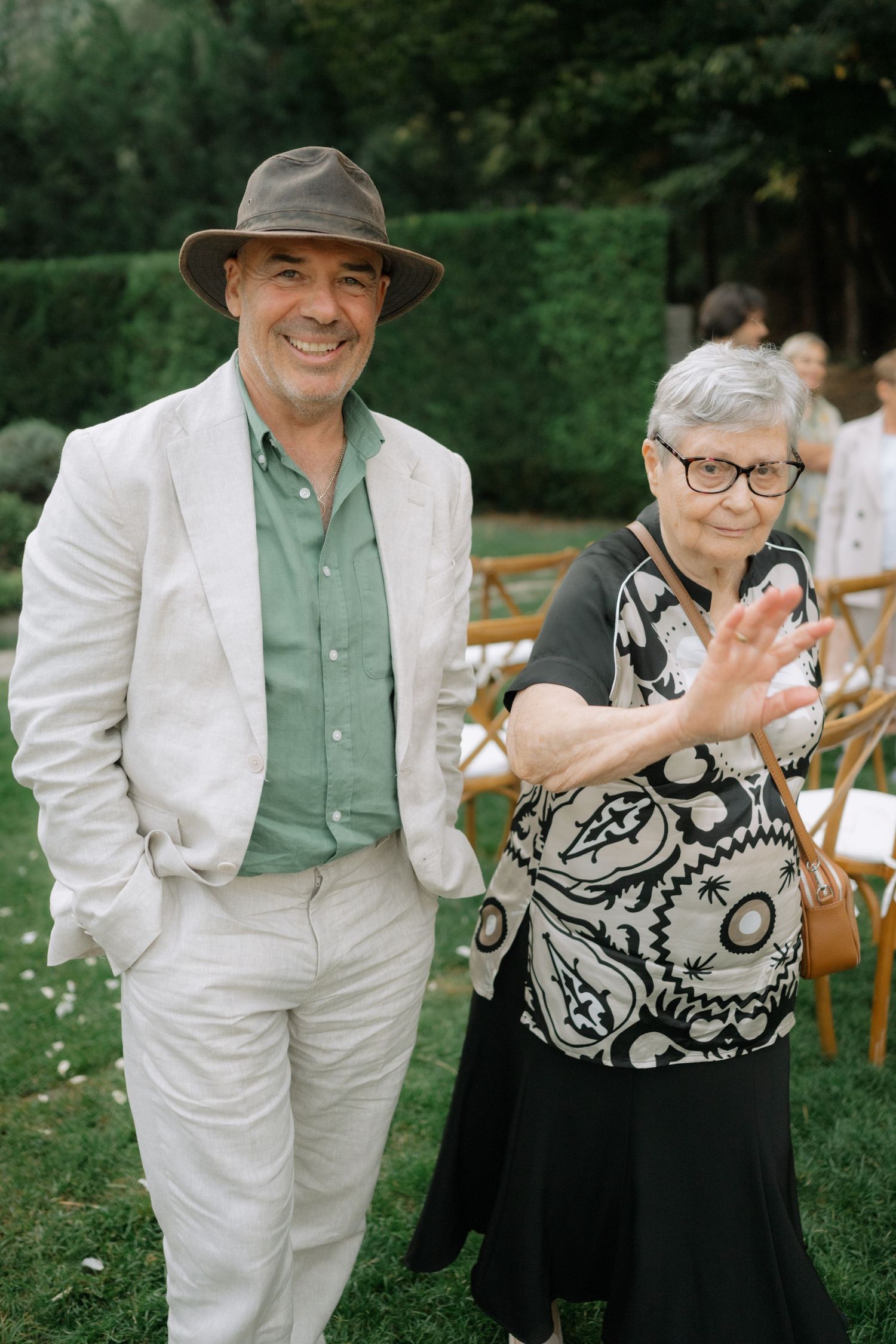 A heartwarming moment captured at an outdoor gathering showing people in coordinated black and white formal attire.