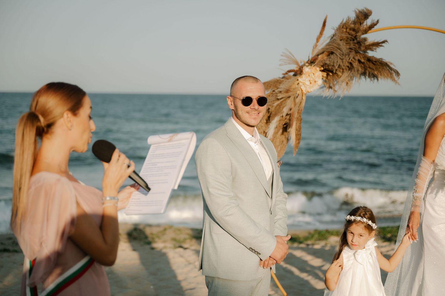 A collage of beach wedding moments showing couples and guests celebrating on a sandy shoreline at sunset.