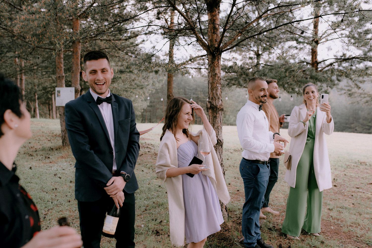 Guests gathering on a grassy lawn for an outdoor celebration event.