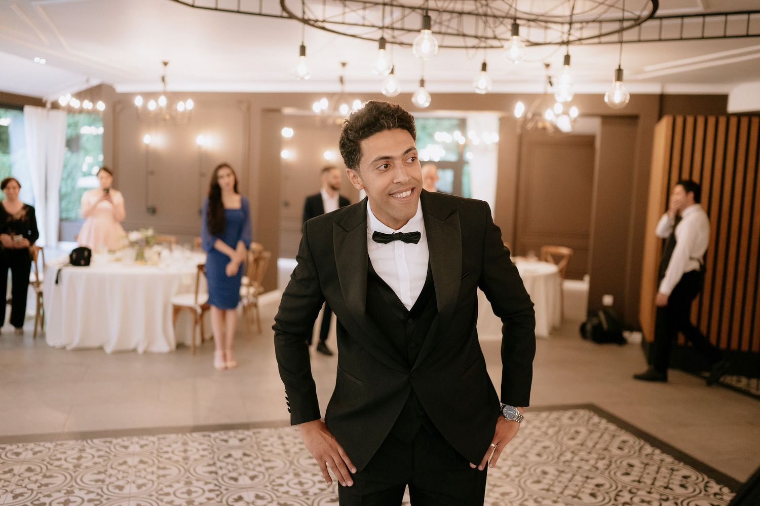 Elegant ballroom with chandelier lighting and guests dancing at a formal event.