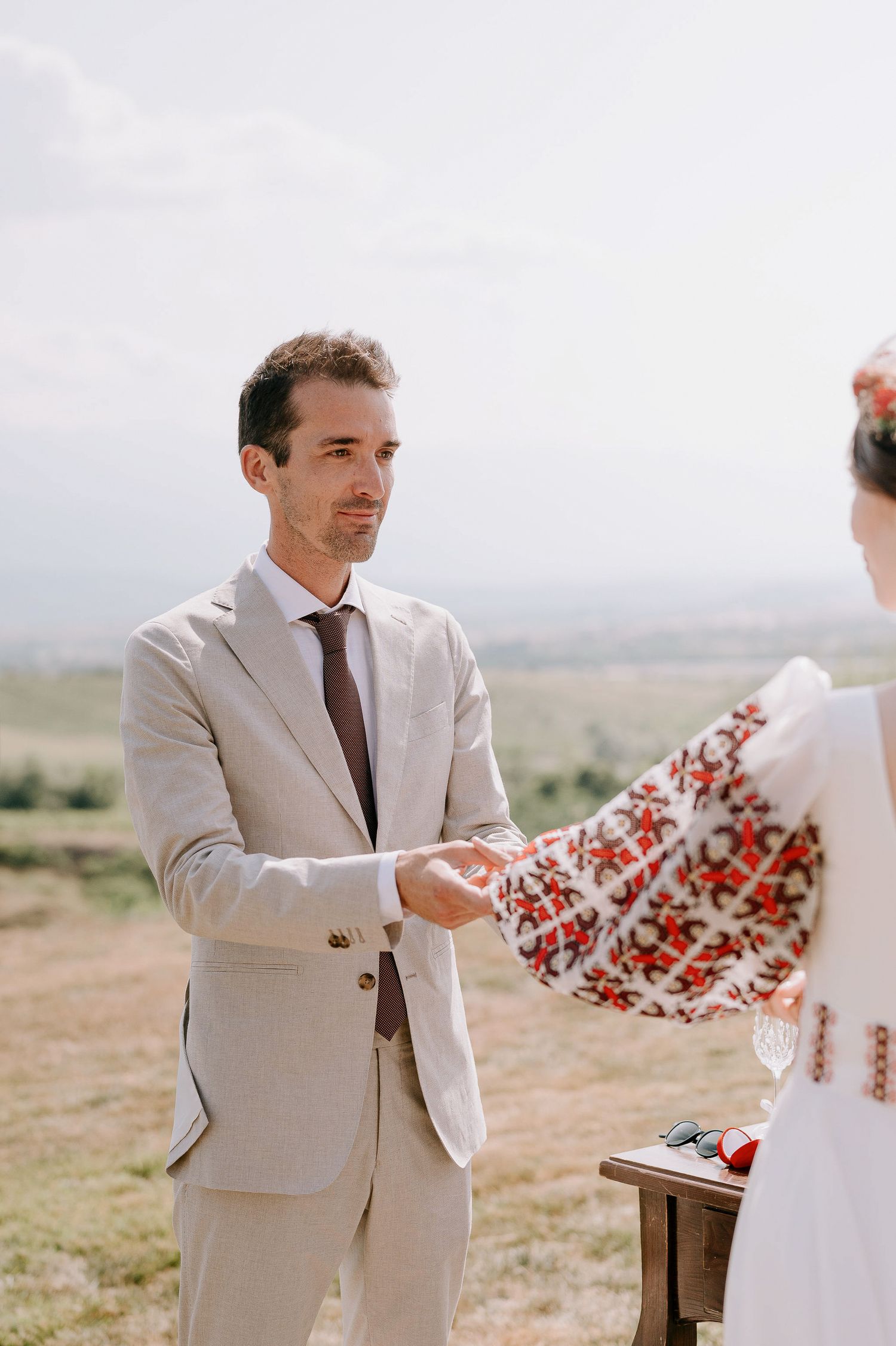 A wedding ceremony moment captured in warm sunlight with desert landscape in background.
