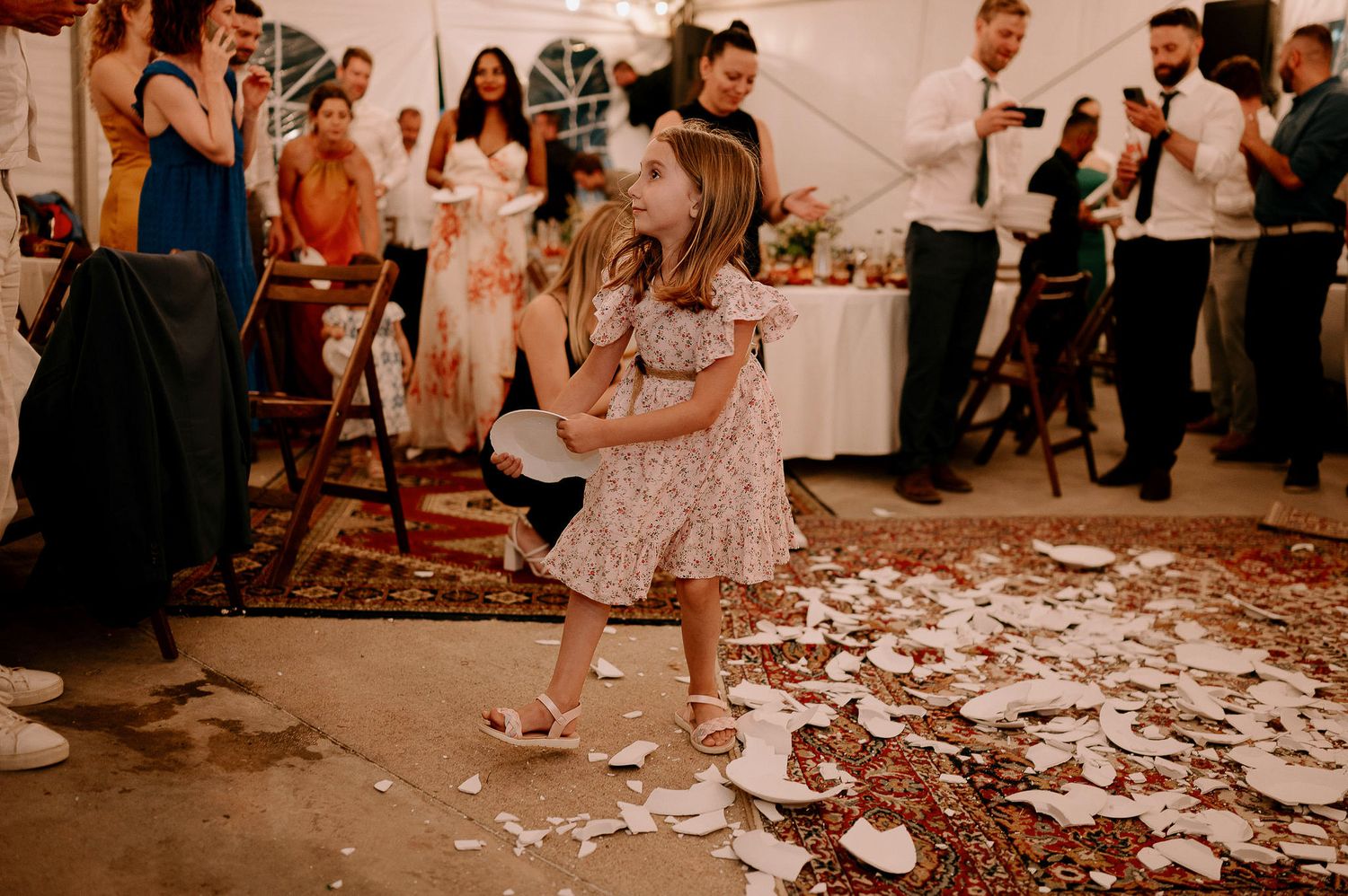 Celebratory scene with guests dancing and confetti scattered across the floor at an indoor event.