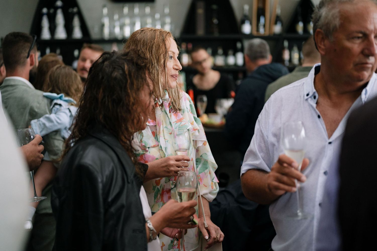 Guests gather at a bar area during an indoor celebration event.