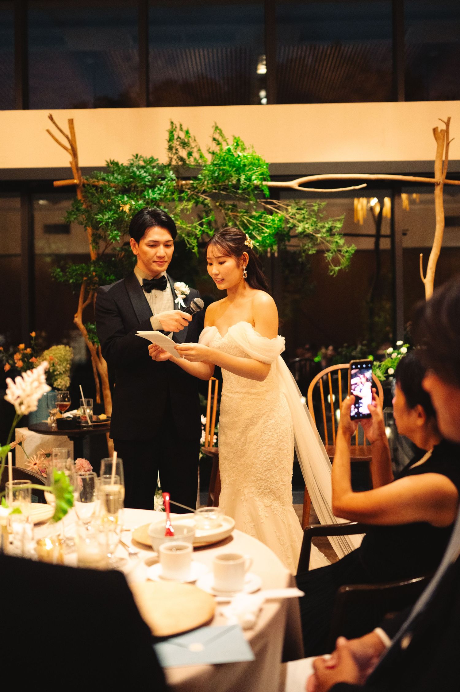 Elegant reception dinner scene with decorative lighting and table settings.