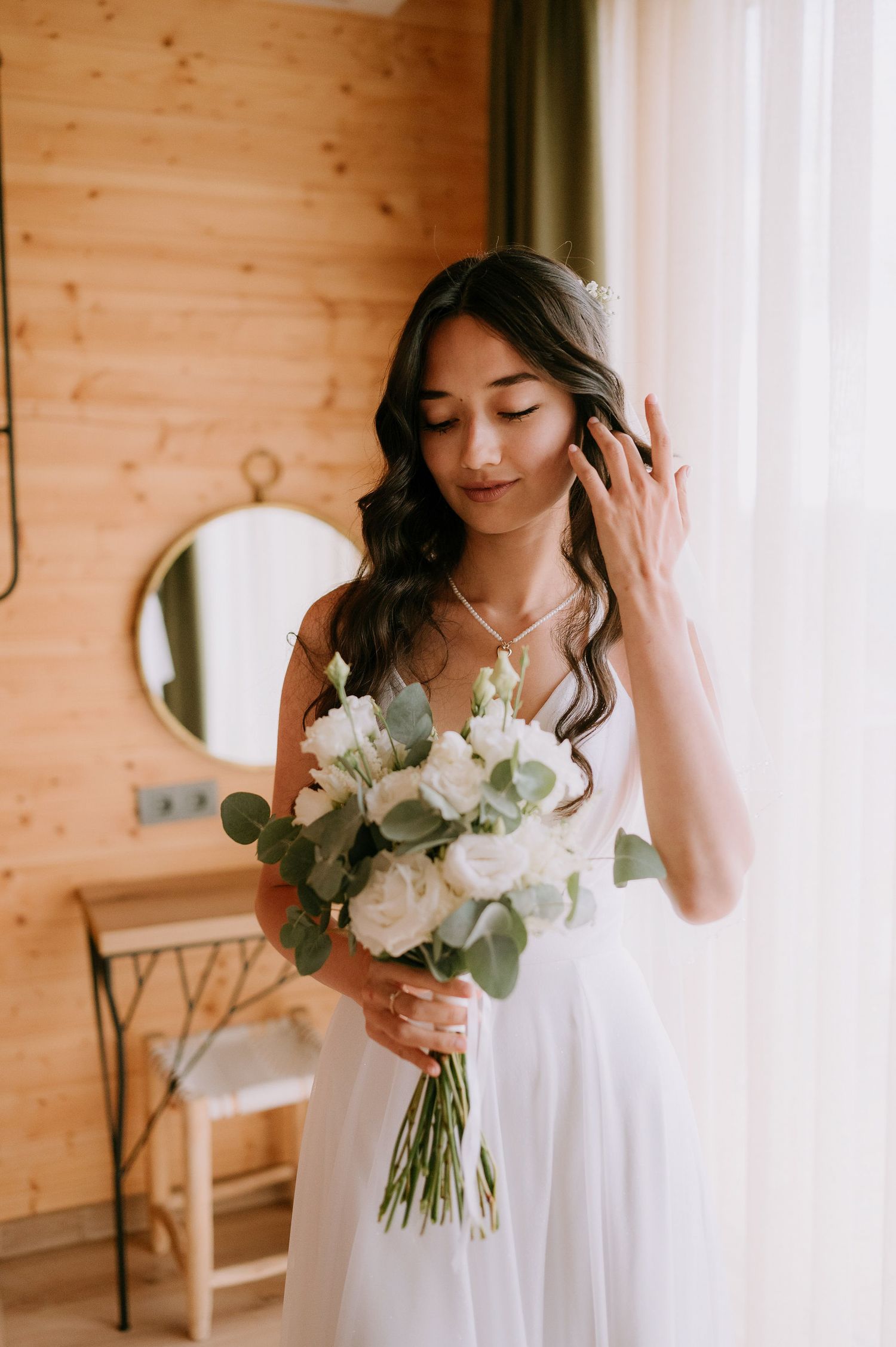 Intimate bridal portraits with white roses and eucalyptus bouquet in rustic setting.