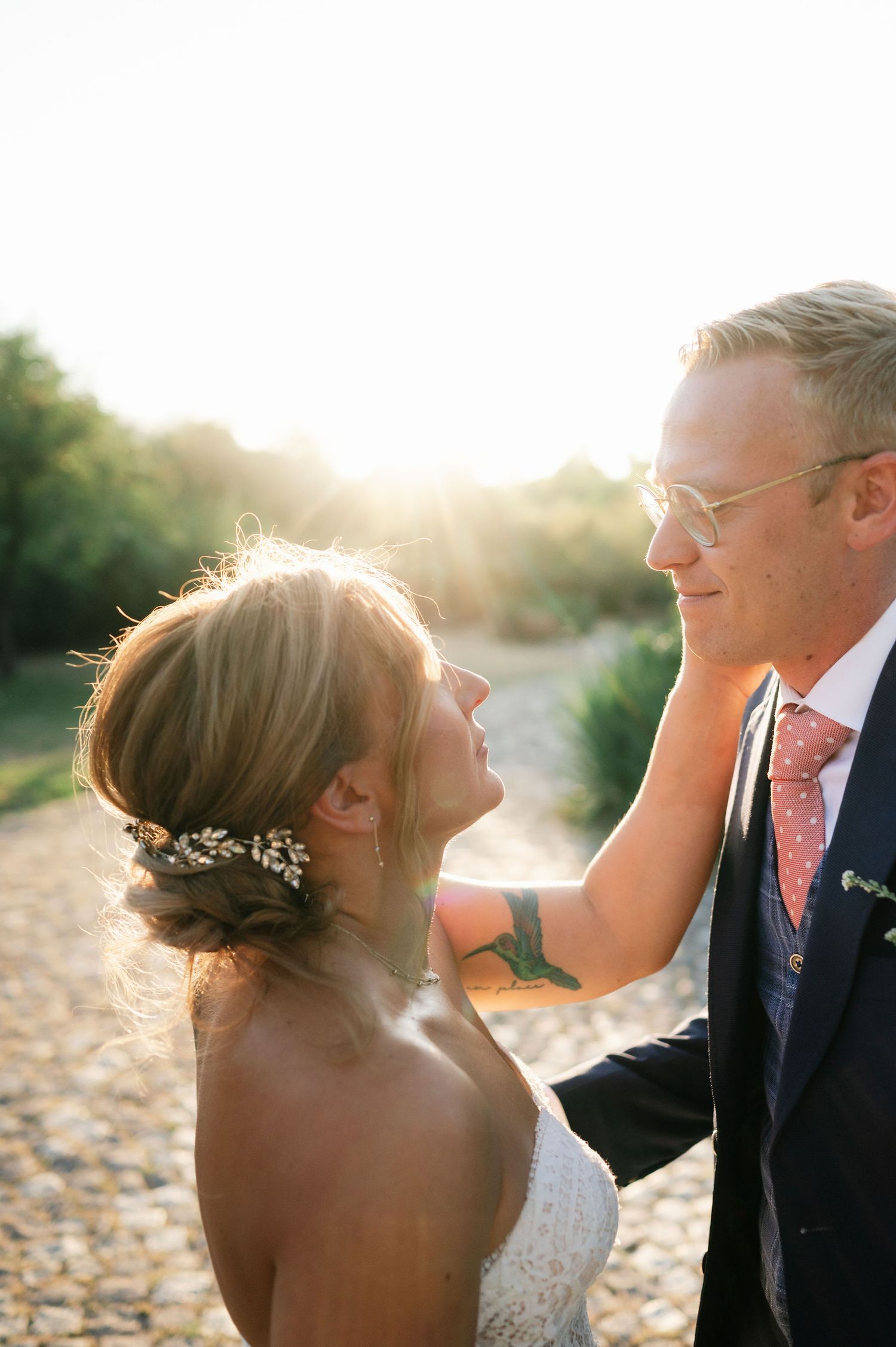 Tender moment between bride and groom captured in warm evening light.