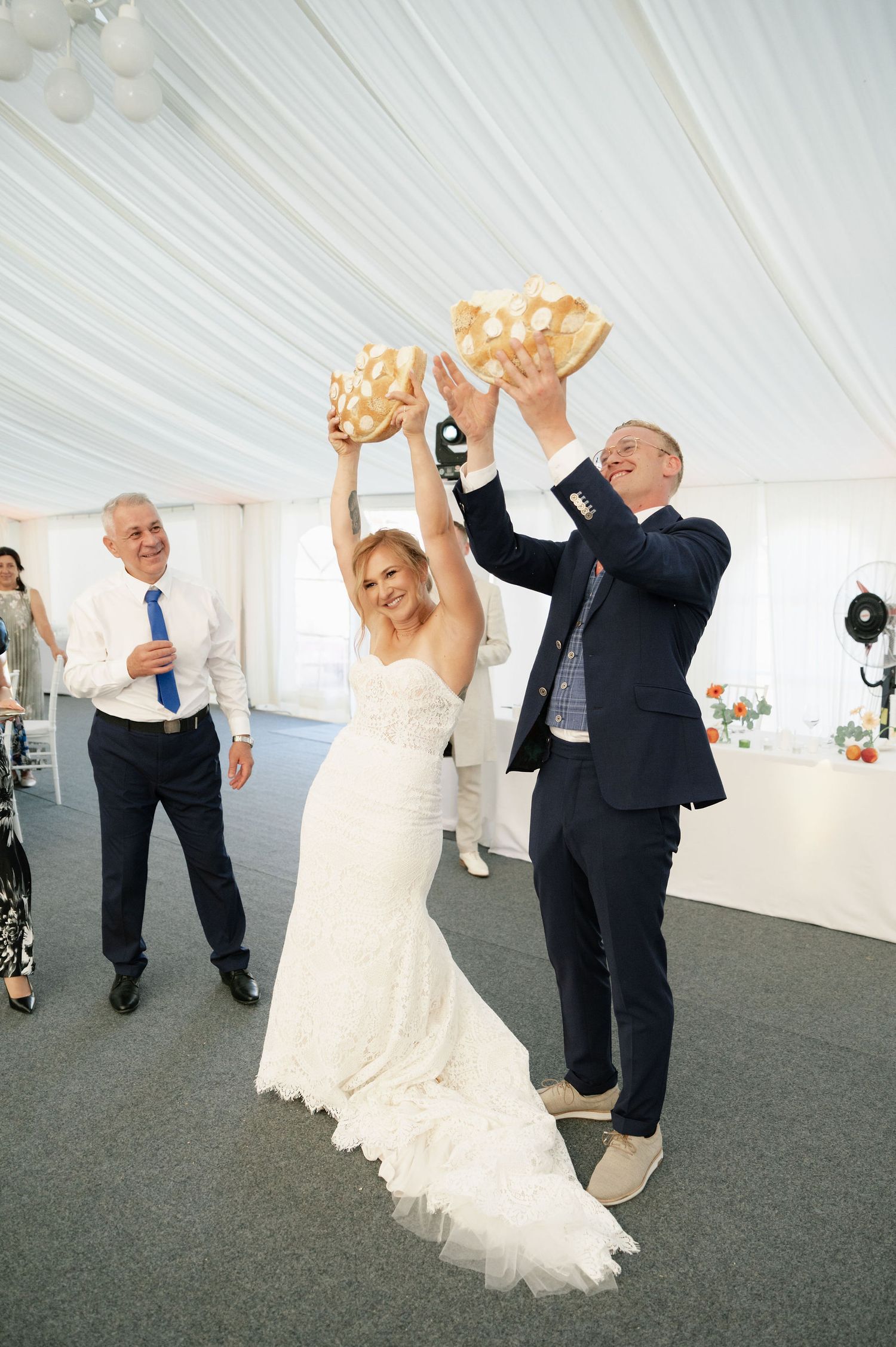 Couples dancing and celebrating at an elegant tented wedding reception.