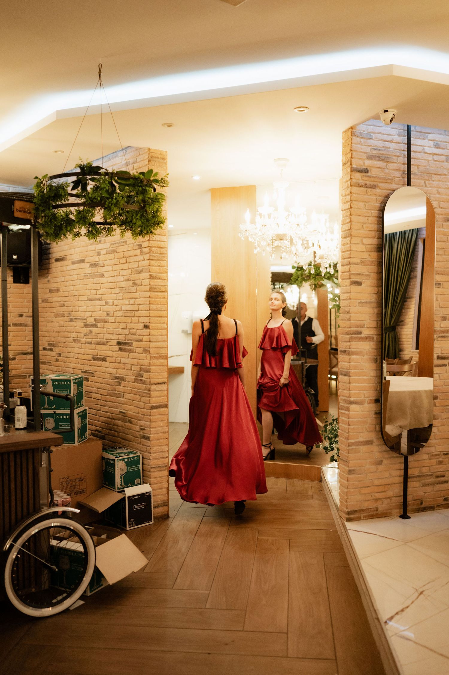 Interior view of a modern beauty salon with brick walls, red dresses on display, and a vintage bicycle decoration.