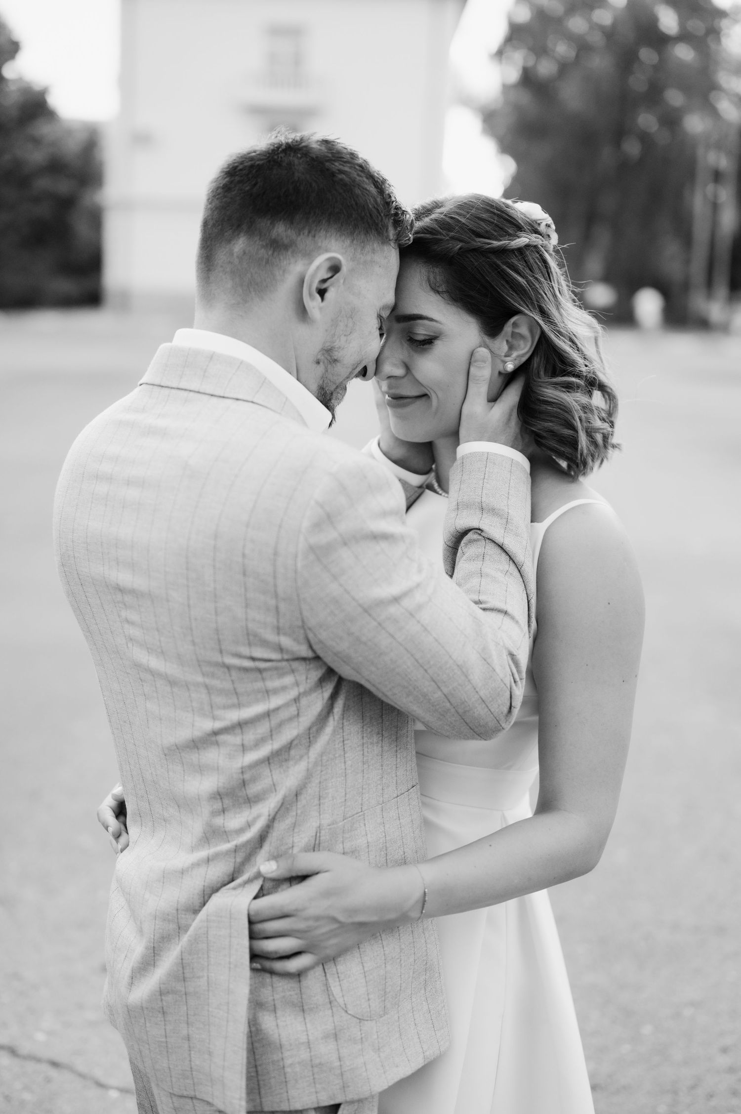 A romantic black and white photo series showing tender moments between a couple embracing outdoors.