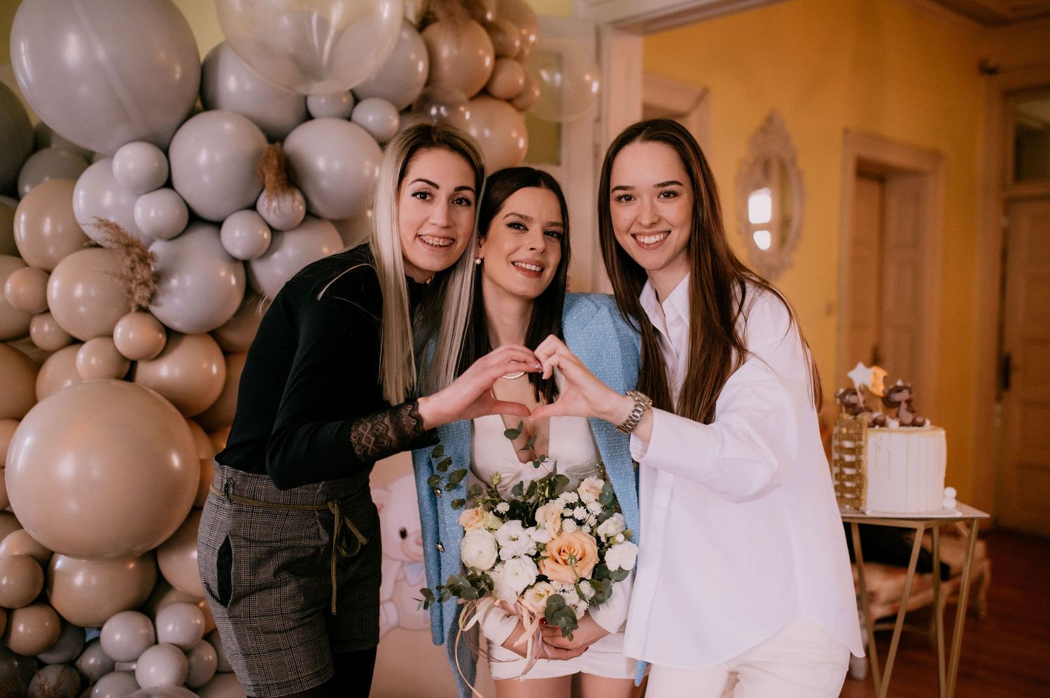A wedding celebration with silver and white balloon decorations and people gathered in an elegant indoor venue.
