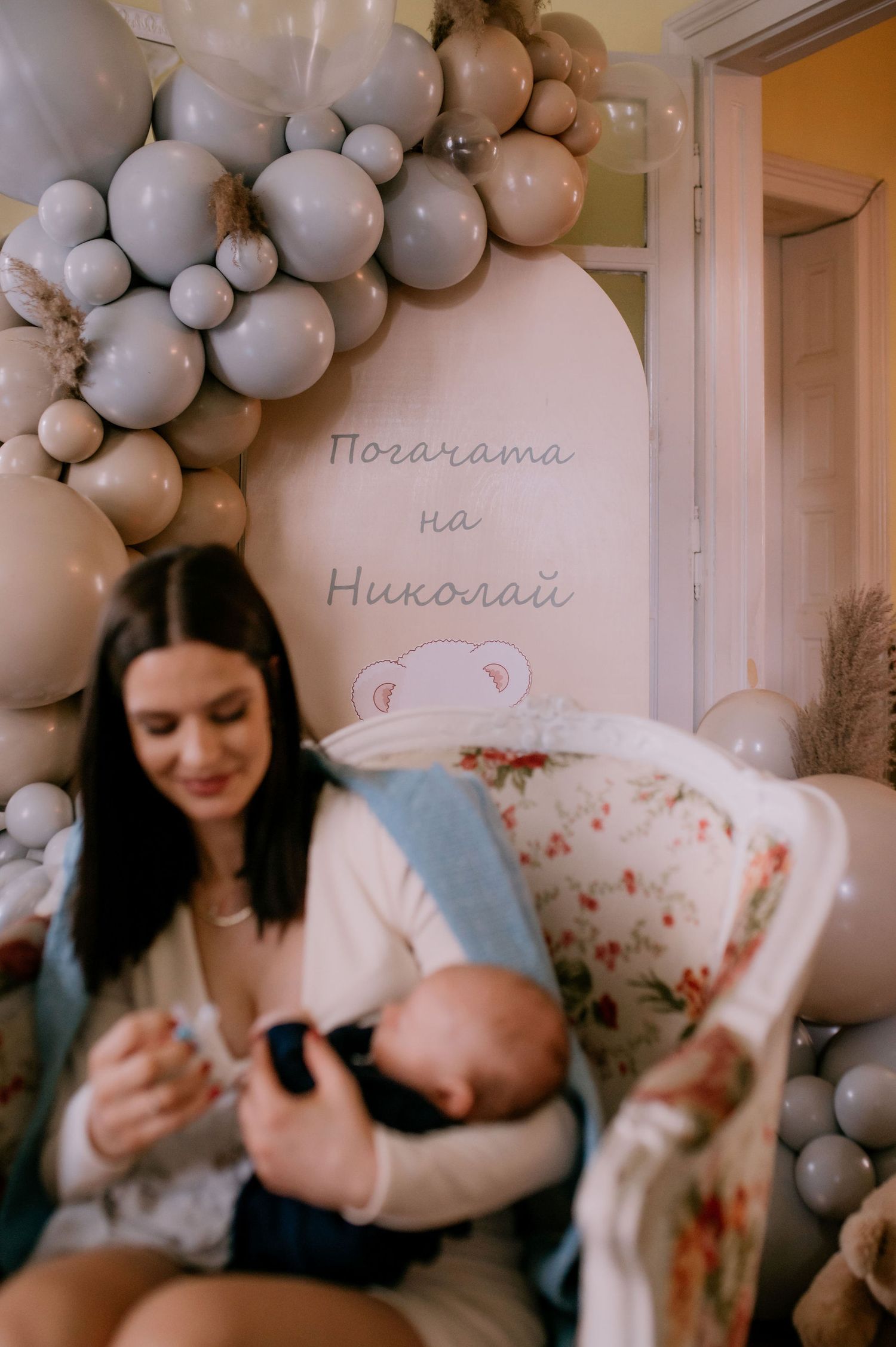 A series of photos showing tender moments with a baby surrounded by soft gray and white balloon decorations.