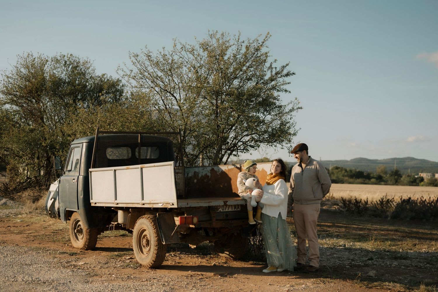 A collection of vintage sepia photographs showing rural farming scenes with trucks and workers in fields during harvest time.