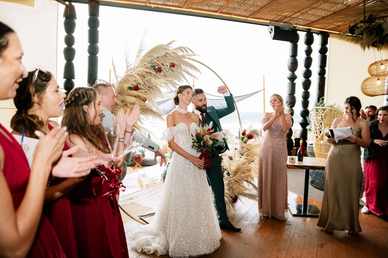 Wedding guests share joyful reactions during reception festivities in an elegant indoor space.