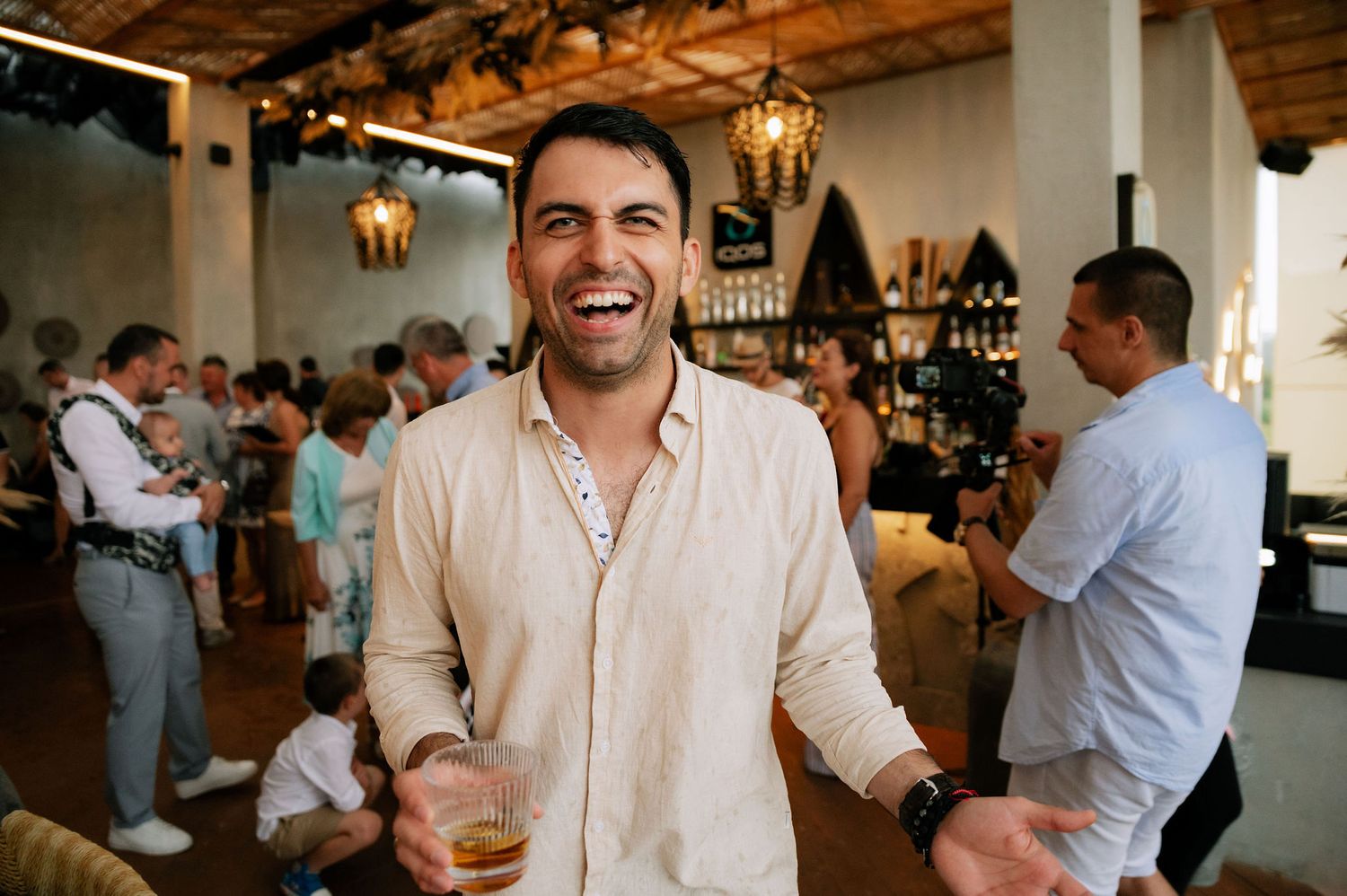 Candid moments of guests enjoying themselves at an indoor celebration.