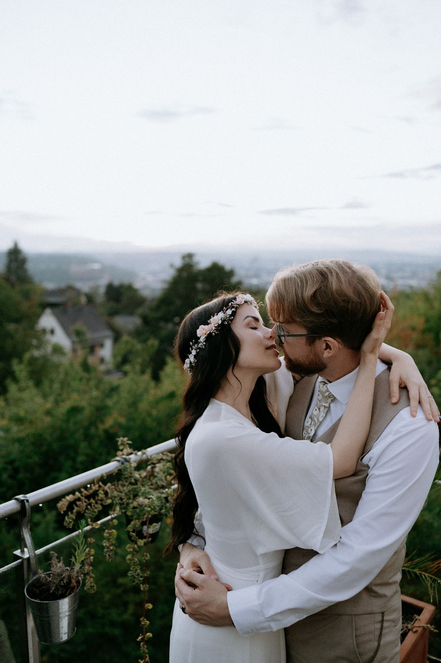 A romantic outdoor photoshoot with city views in the background at dusk.