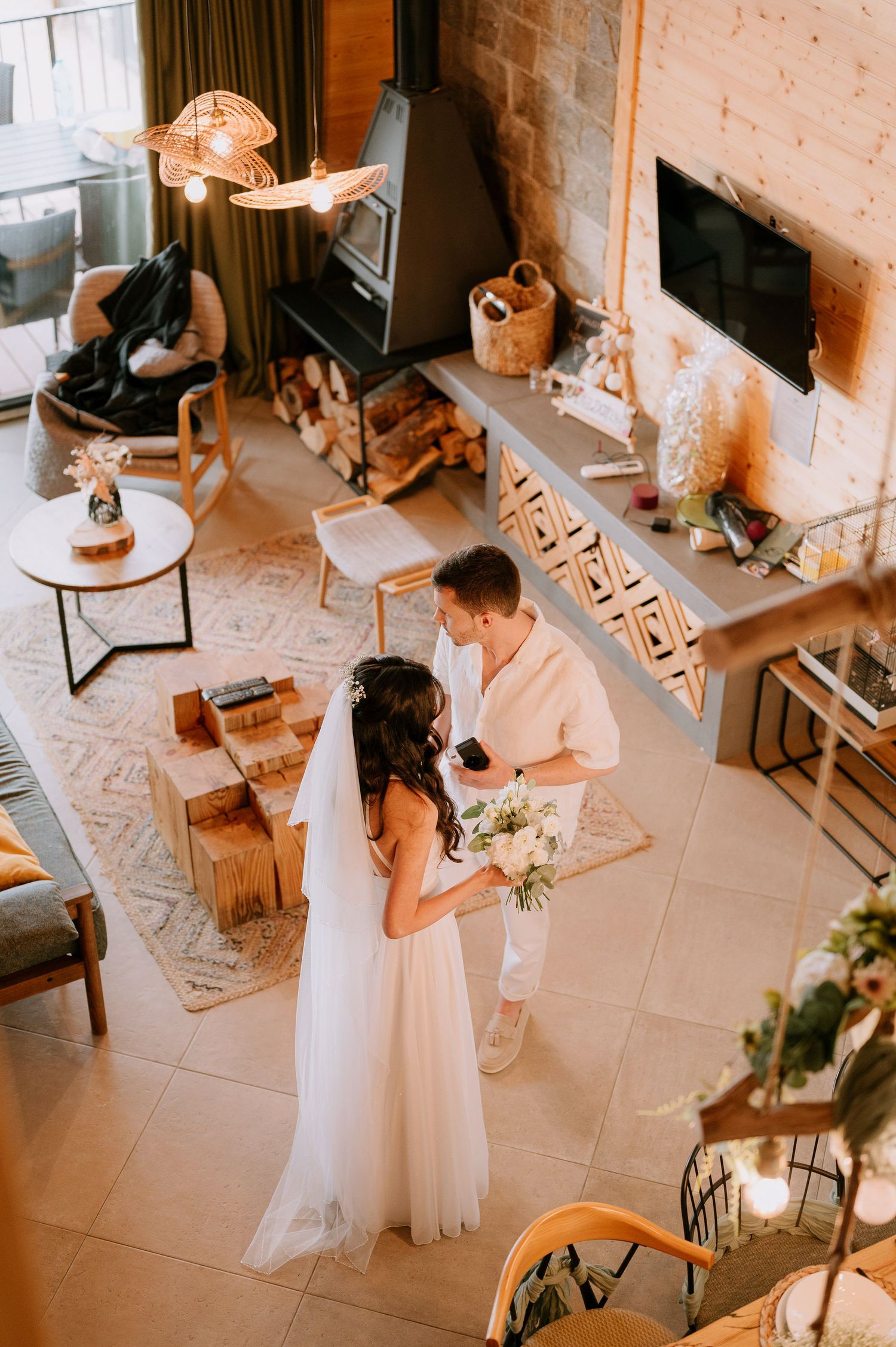 Intimate wedding venue interior with table settings and warm lighting from an aerial perspective.