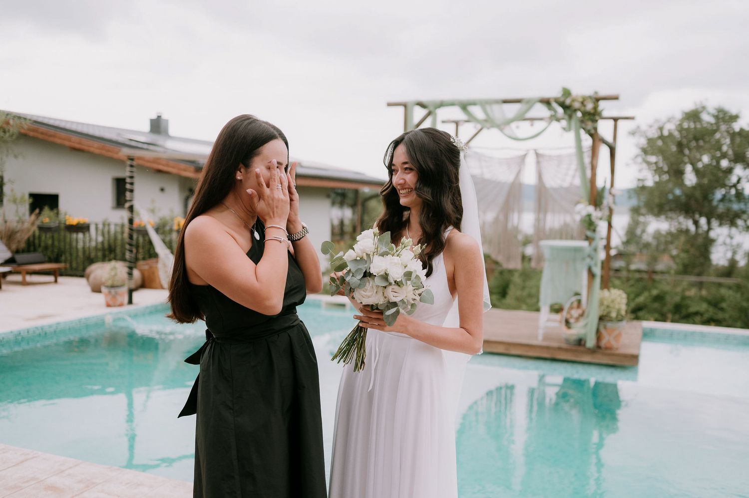 Intimate poolside wedding ceremony with macrame decorations and mountain views.