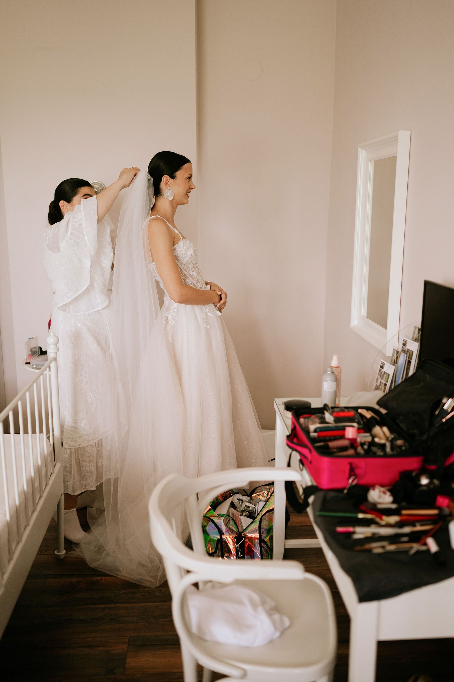 Wedding preparation scene with white dress and accessories in a bright room.