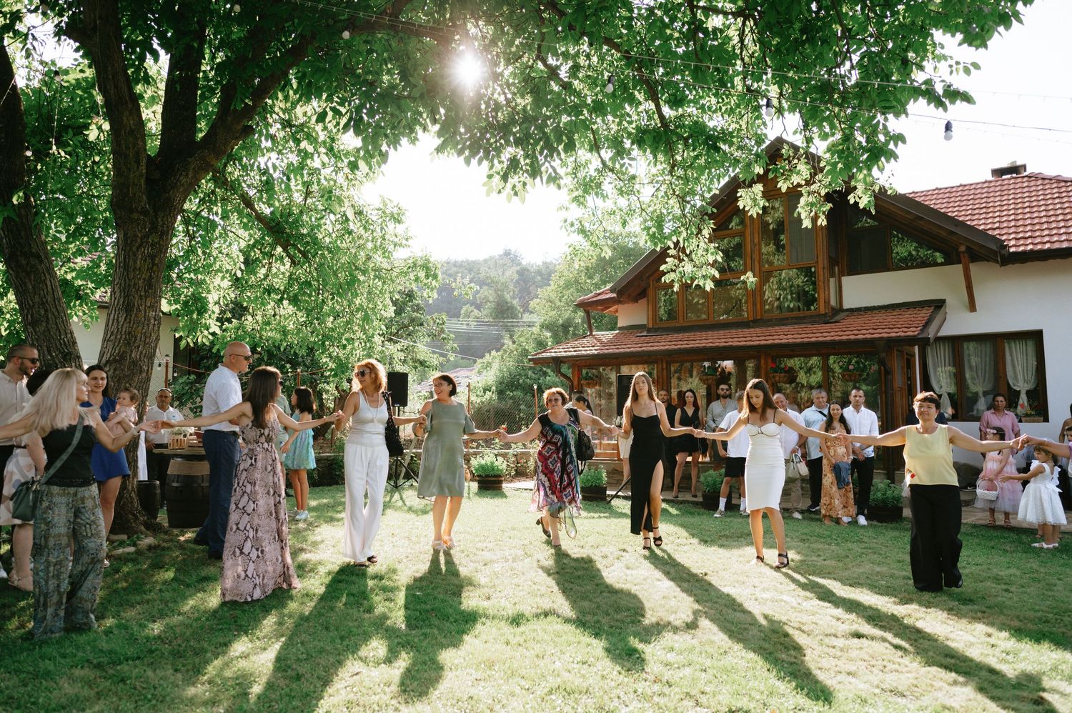 Outdoor wedding venue with large trees casting shadows during golden hour.