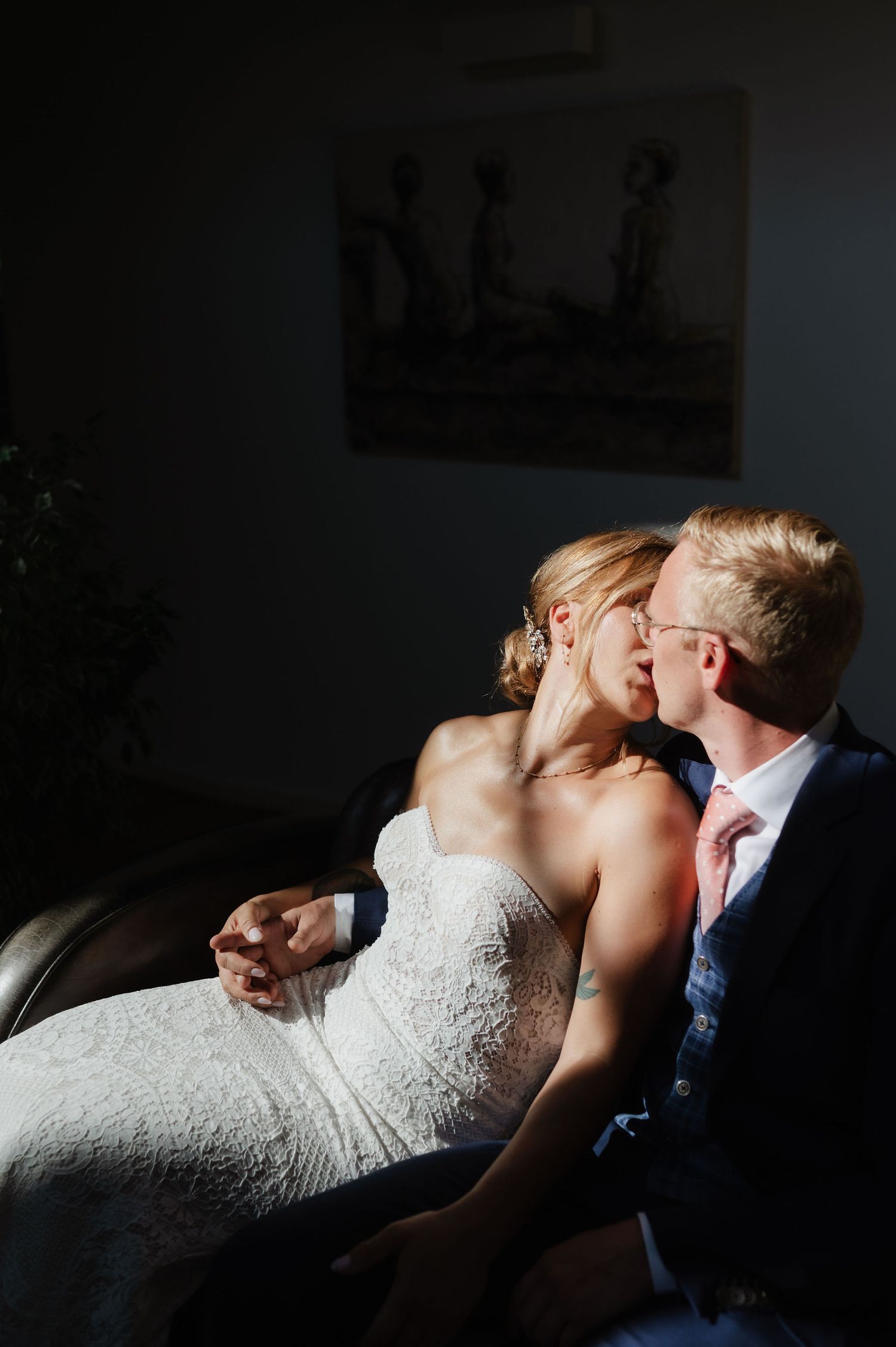Artistic black and white portrait of wedding couple in dramatic lighting.