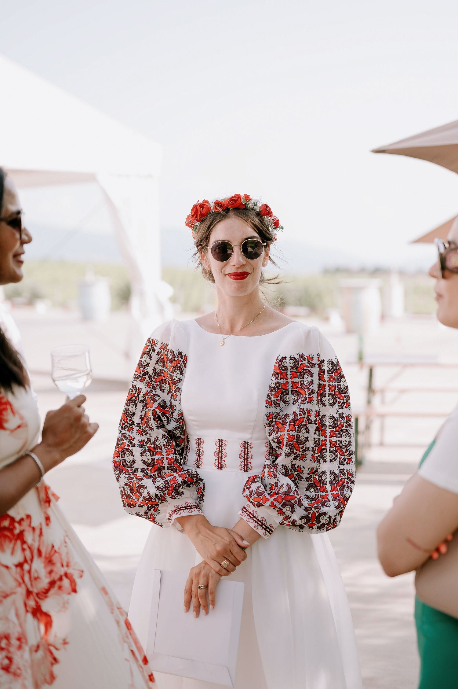 Traditional embroidered white and red folk dress with puff sleeves and floral crown creates an elegant bridal look.