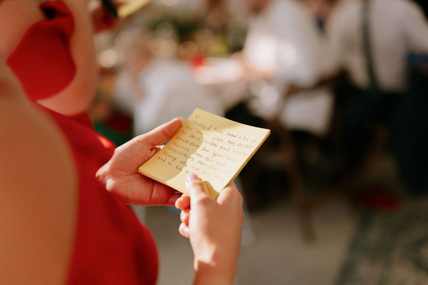 Close-up shot of hands holding paper at a wedding reception.