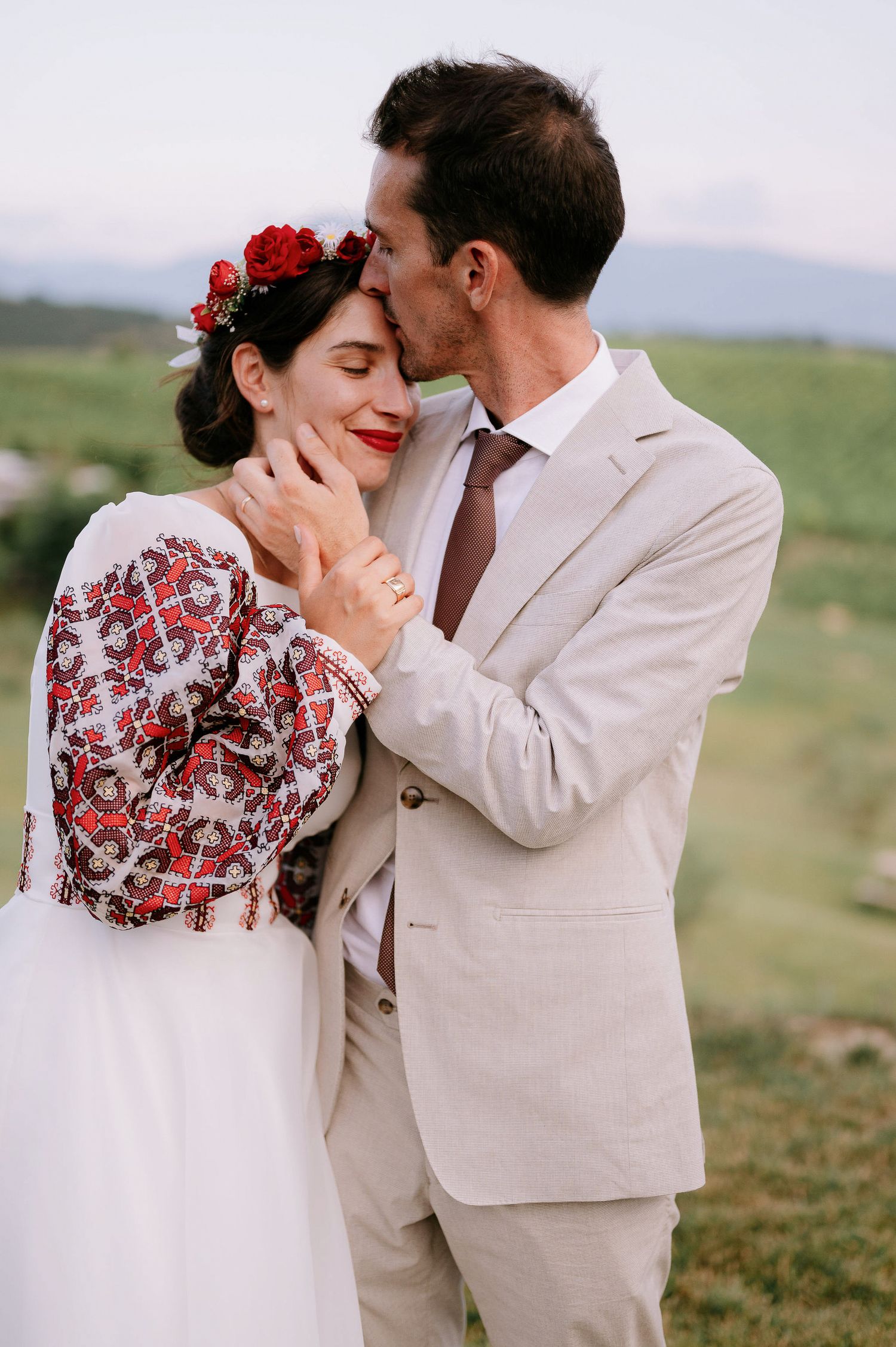 Intimate wedding portrait showing tender affection in a scenic countryside setting.